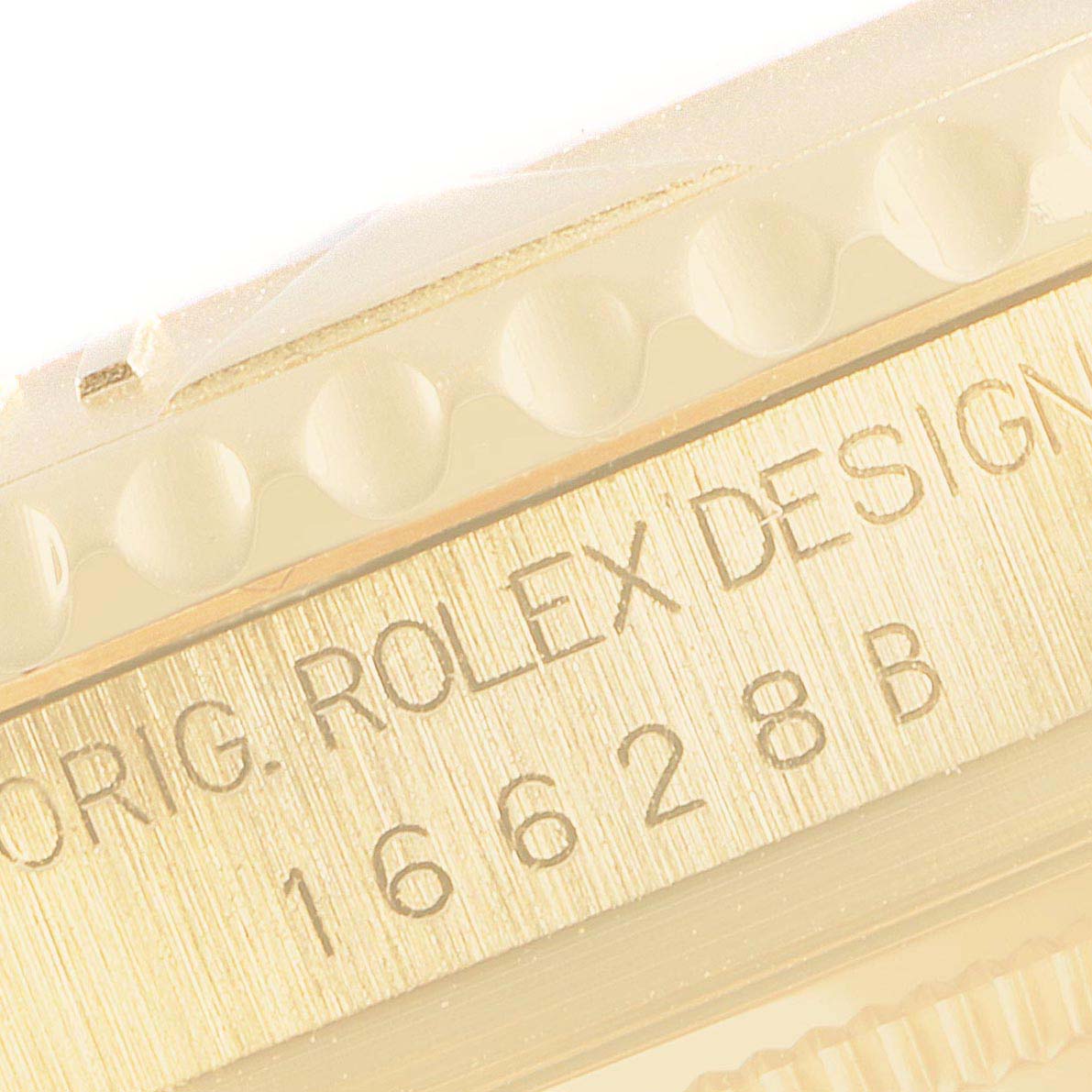 This close-up shows the bezel and case side of the Rolex Yacht-Master 16628 Men's Yellow Gold White Dial 16628 Men's Yellow Gold White Dial, including the model number and designer's engraving.