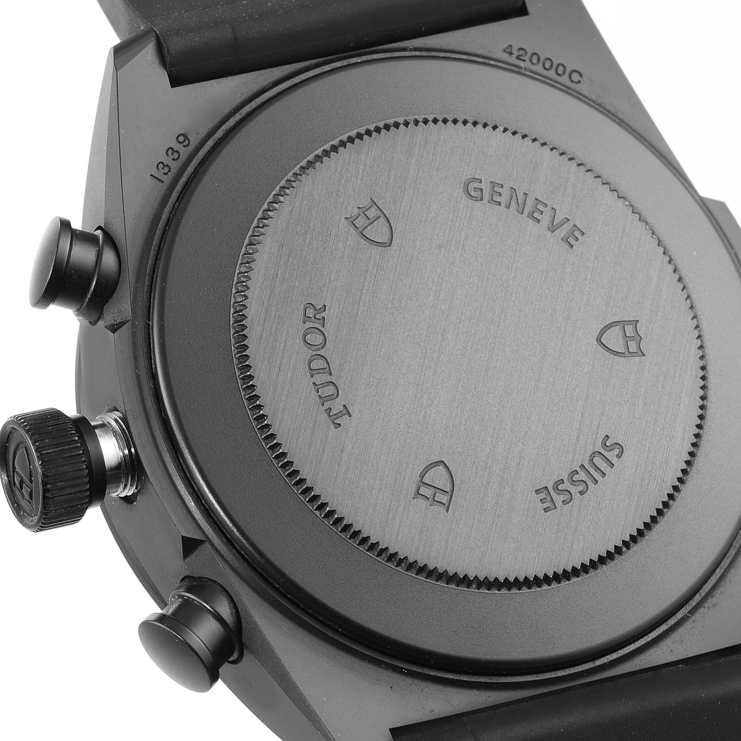 This image shows the back casing of a Tudor Fastrider 42000CR Men's Ceramic Black Dial 42000CR Men's Ceramic Black Dial watch, highlighting the engraved details and pushers.