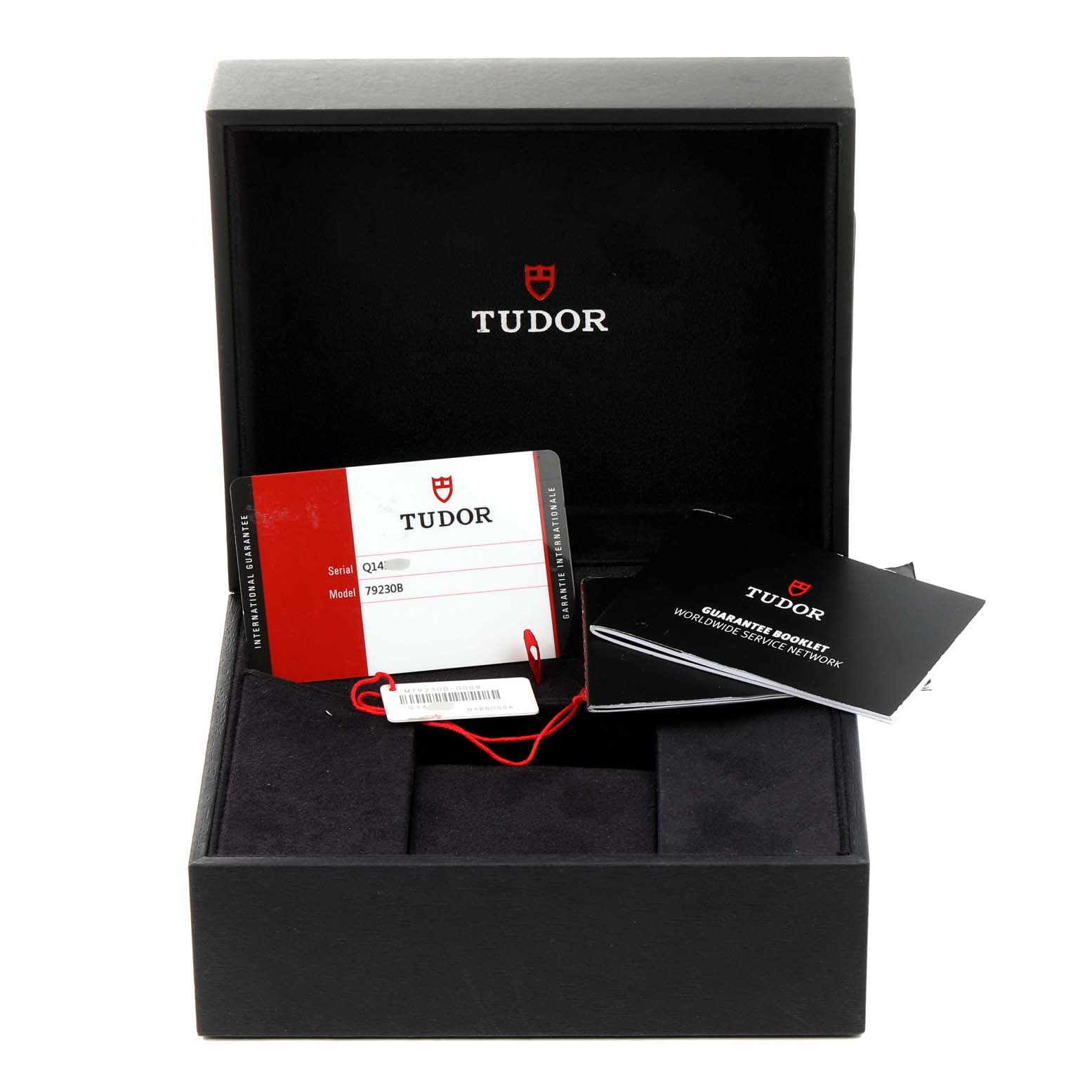 The image shows an open box for the Tudor Heritage Black Bay 79230B Men's Stainless Steel Black Dial 79230B Men's Stainless Steel Black Dial watch, displaying guarantee booklets and a warranty card.