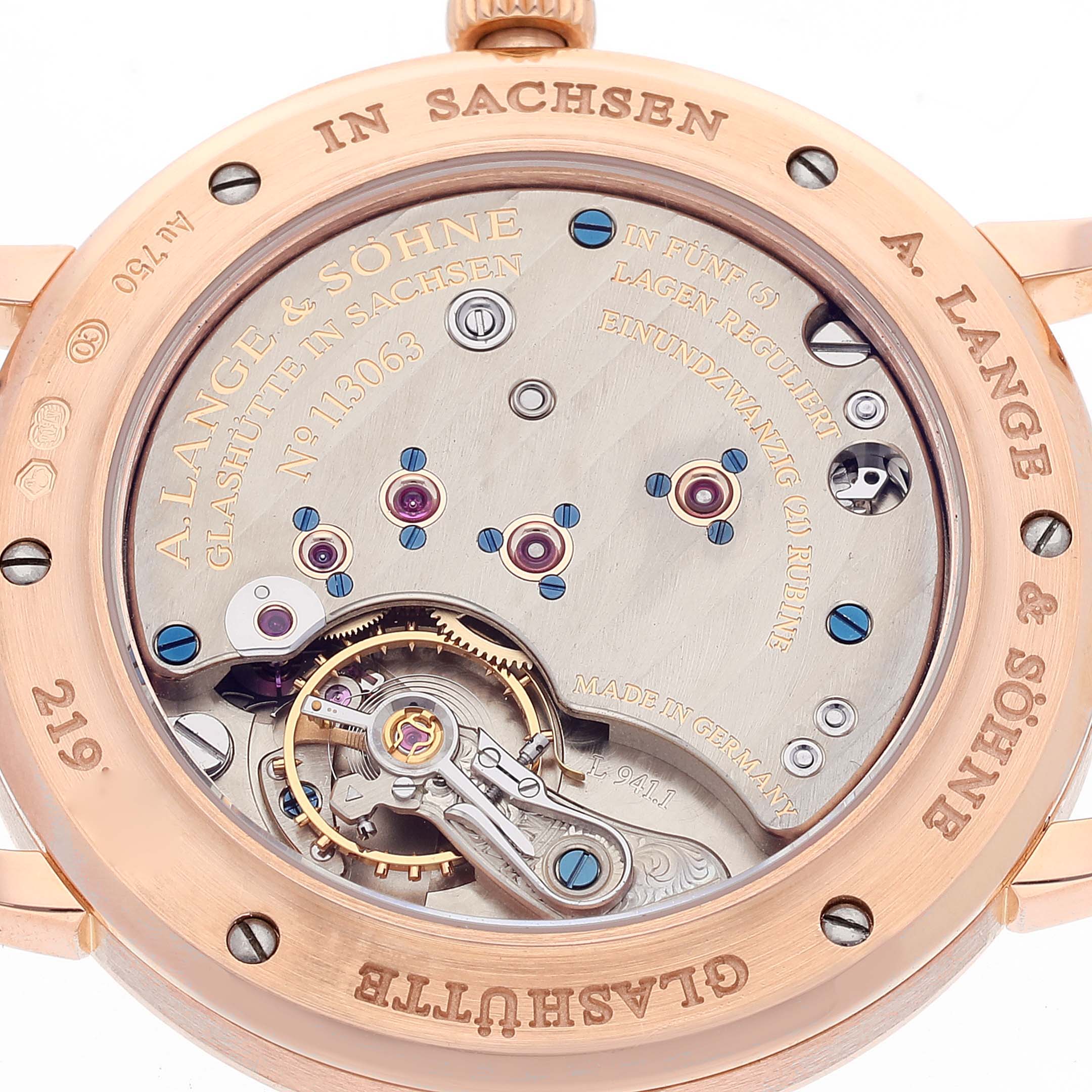 The image shows the back view of the A. Lange & Sohne Saxonia 219.032 Men's Rose Gold Silver Dial watch, showcasing its intricate movement and engravings.
