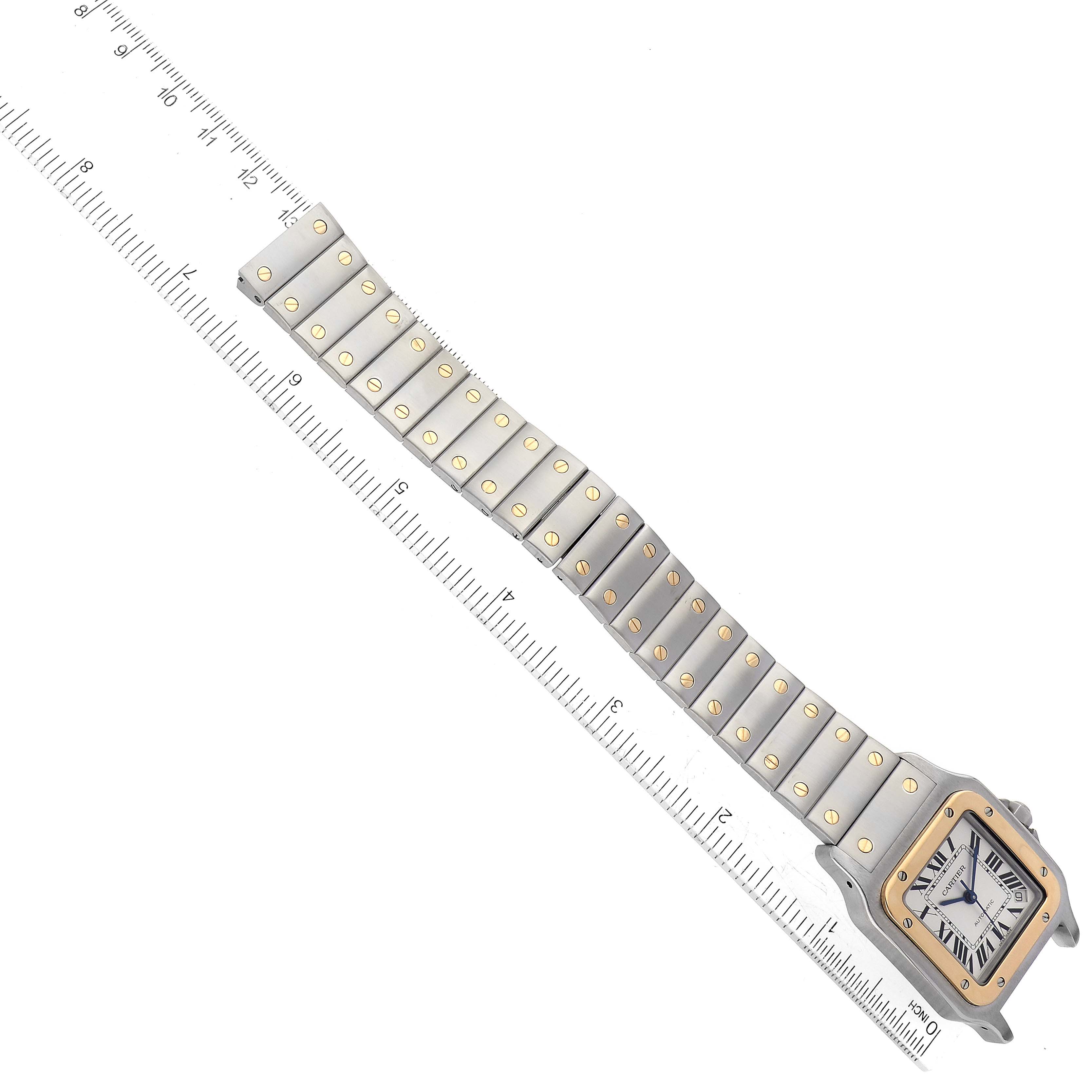 The Santos model by Cartier is shown from a top-down angle, displaying the face, bezel, and entire bracelet with a measuring scale.