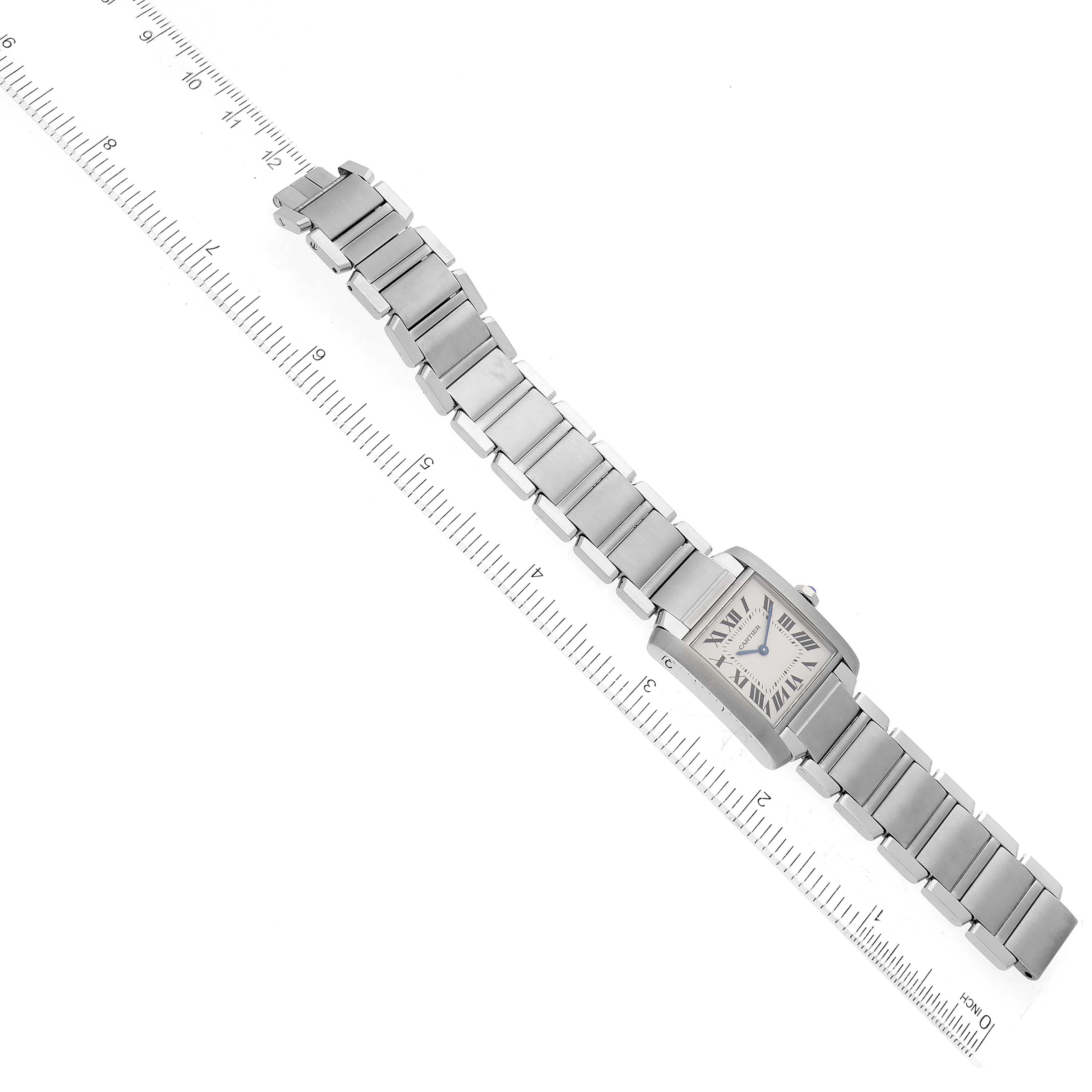 The Cartier Tank Francaise WSTA0005 Women's Stainless Steel Silver Dial WSTA0005 Women's Stainless Steel Silver Dial watch is shown from an overhead angle, displaying its face, bracelet, and clasp next to a ruler for scale.