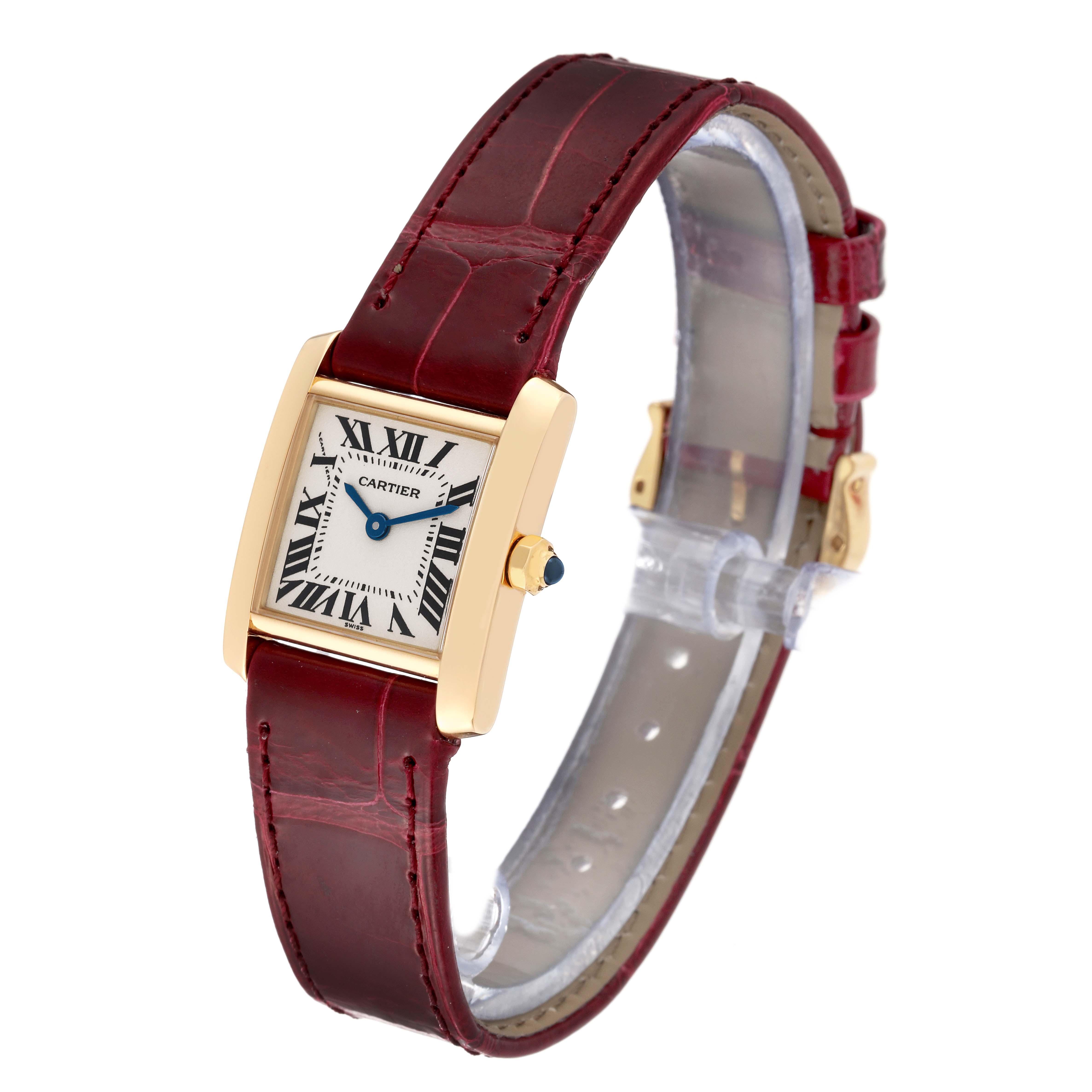 The Cartier Tank Française watch is shown at a three-quarter angle, featuring its face, red leather strap, and gold casing.