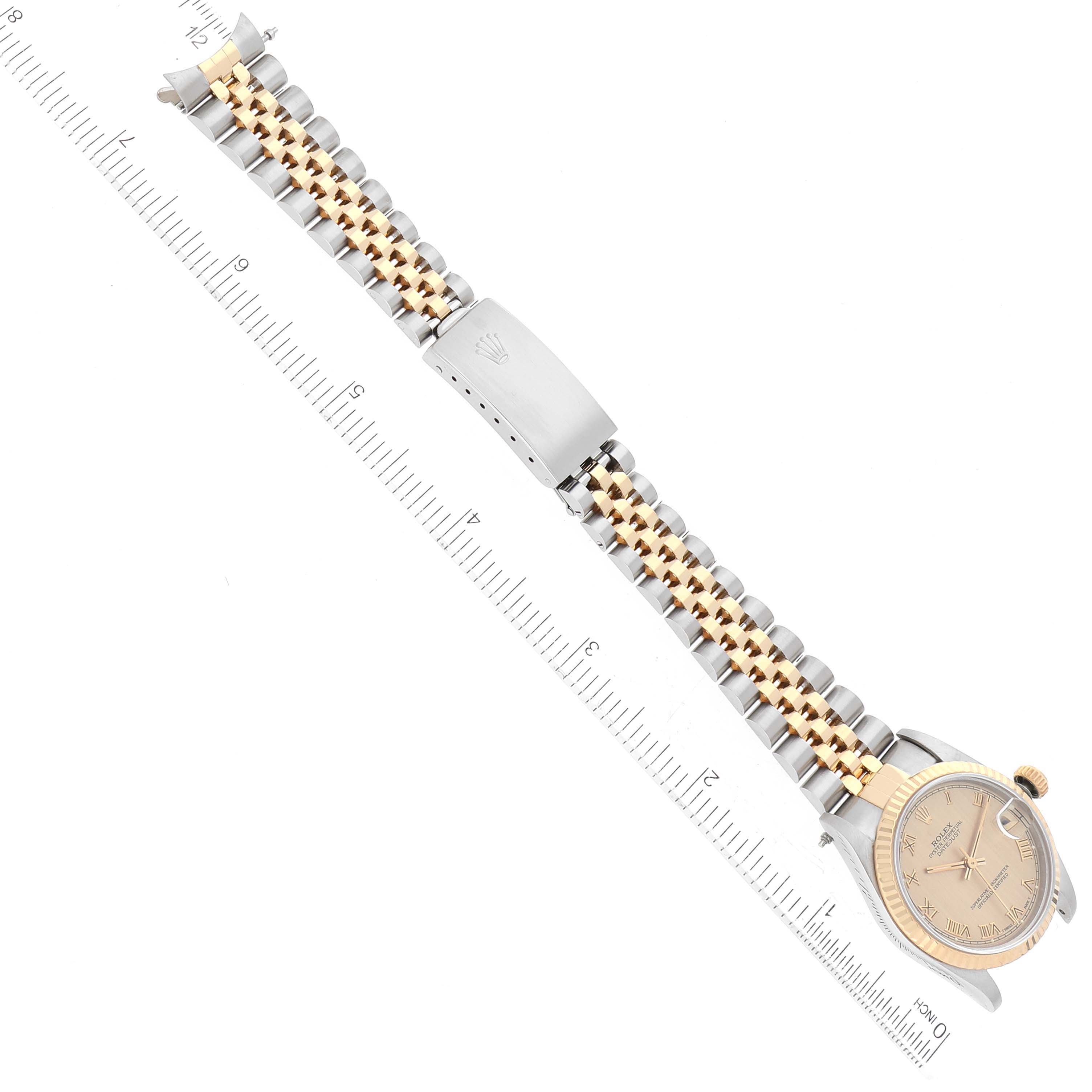 This image of the Rolex Mid-Size 68273 Women's Steel and Gold (two tone) Champagne Dial 68273 Women's Steel and Gold (two tone) Champagne Dial watch shows the face, bezel, strap, and clasp, aligned diagonally next to a ruler for scale.