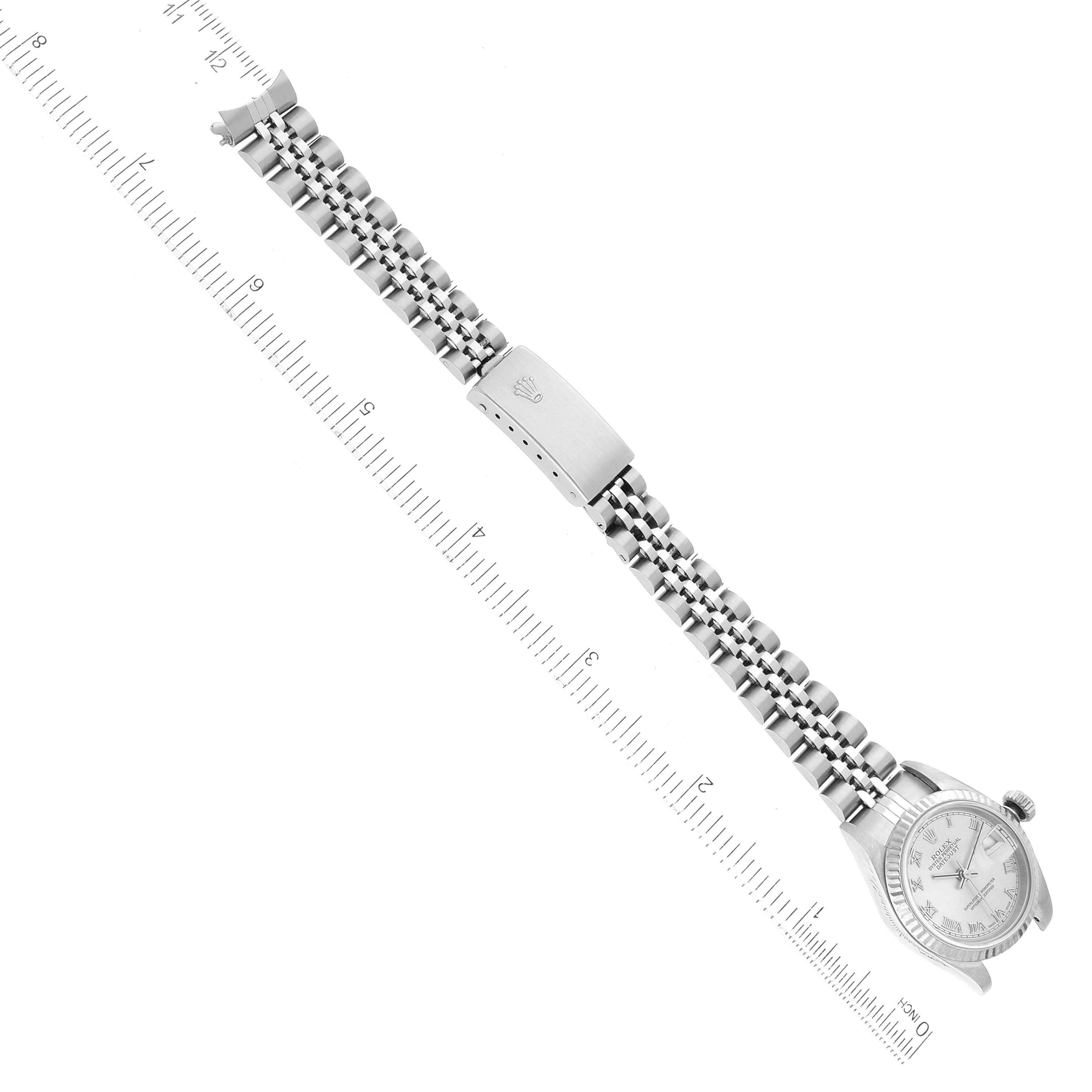 The image shows a top view of a Rolex Datejust 79174 Women's Stainless Steel Silver Dial 79174 Women's Stainless Steel Silver Dial watch and its band, alongside a ruler for size reference.