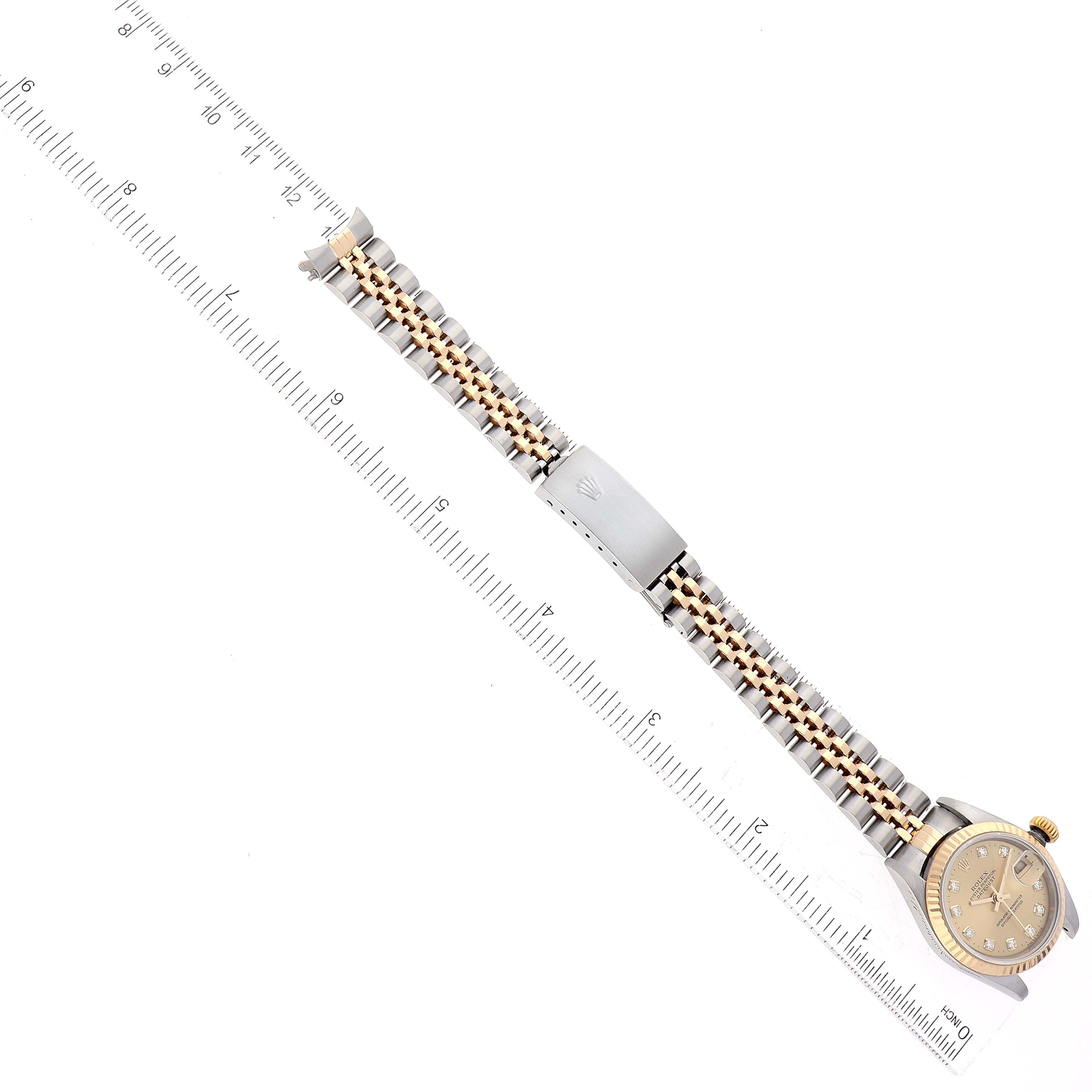 The image shows a Rolex Datejust 79173G Women's Steel and Gold (two tone) Champagne Dial 79173G Women's Steel and Gold (two tone) Champagne Dial watch laid flat with its entire bracelet and clasp visible, next to a ruler for measurement.