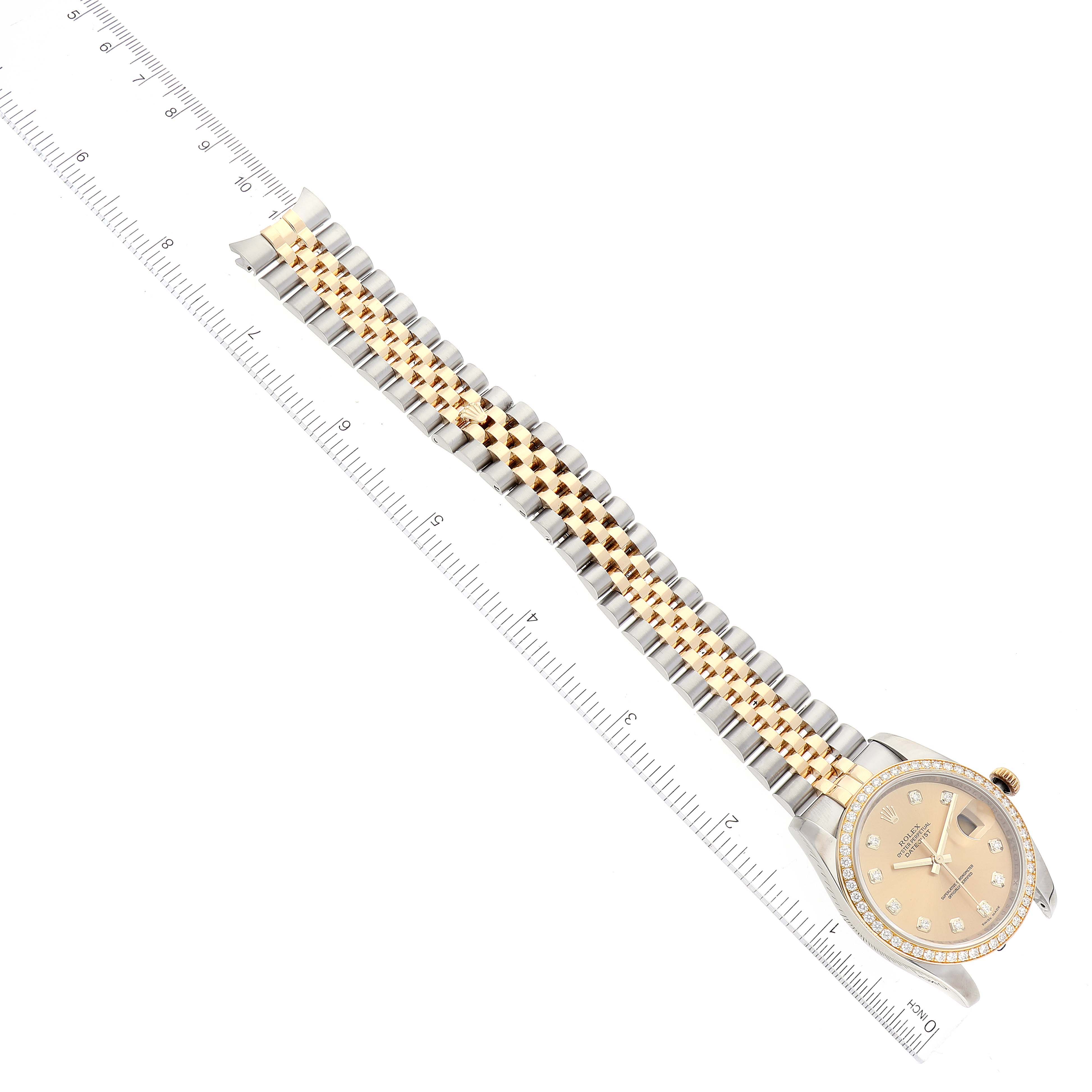 The image shows a Rolex Datejust 116243 Men's Steel and Gold (two tone) Champagne Dial 116243 Men's Steel and Gold (two tone) Champagne Dial watch laid flat, displaying its face and two-tone bracelet alongside a ruler for measurement.