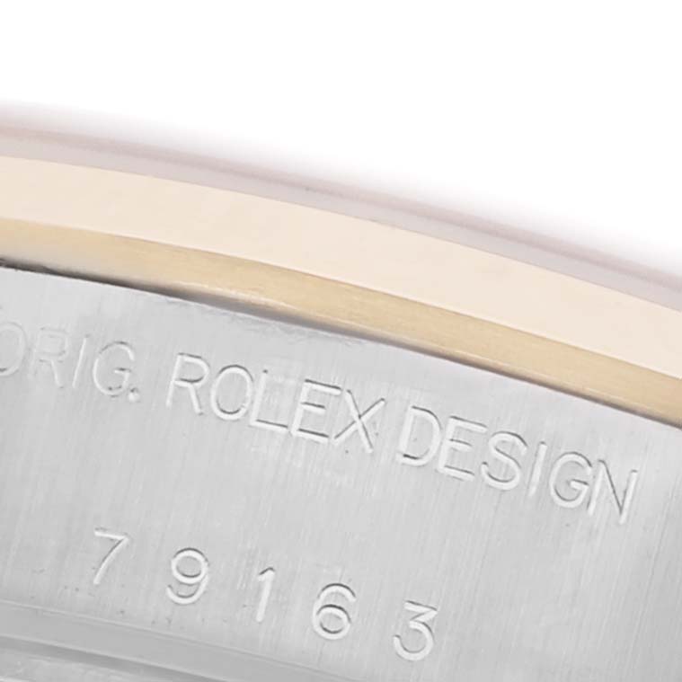 The image shows a close-up of the side of the Rolex Datejust 79163 Women's Steel and Gold (two tone) White Dial 79163 Women's Steel and Gold (two tone) White Dial, featuring engraved text and part of the bezel.
