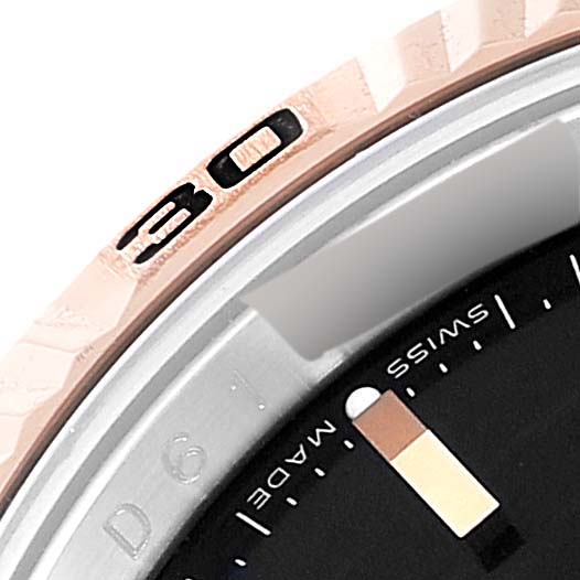 This image shows a close-up angle of the bezel and part of the dial of a Rolex Turn-o-Graph 116261 Men's Steel and Gold (two tone) Black Dial 116261 Men's Steel and Gold (two tone) Black Dial watch.