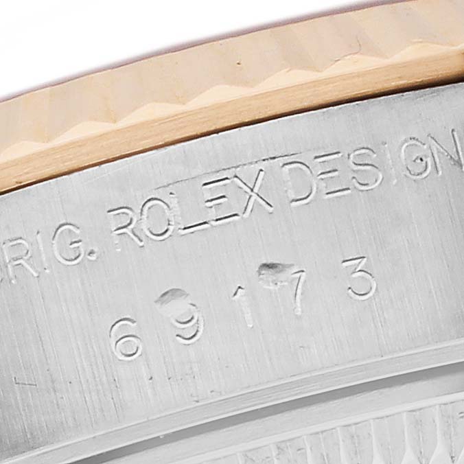 The image shows a close-up of the Rolex Datejust 69173 Women's Steel and Gold (two tone) White Dial 69173 Women's Steel and Gold (two tone) White Dial's edge, highlighting the bezel and engraved design numbers.