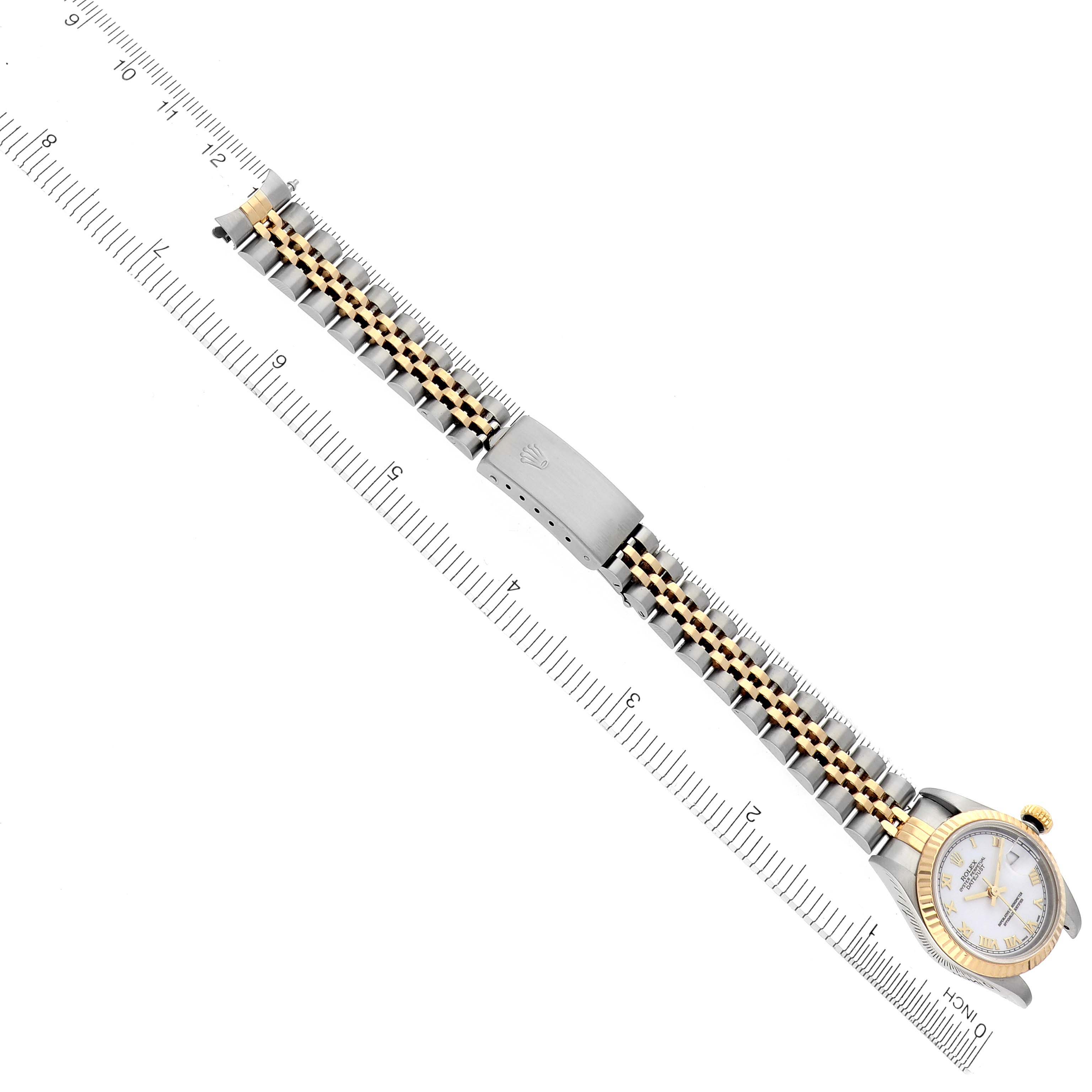 The Rolex Datejust 69173 Women's Steel and Gold (two tone) White Dial 69173 Women's Steel and Gold (two tone) White Dial watch is shown from an overhead angle, displaying the face, bezel, and bracelet aligned with a ruler.