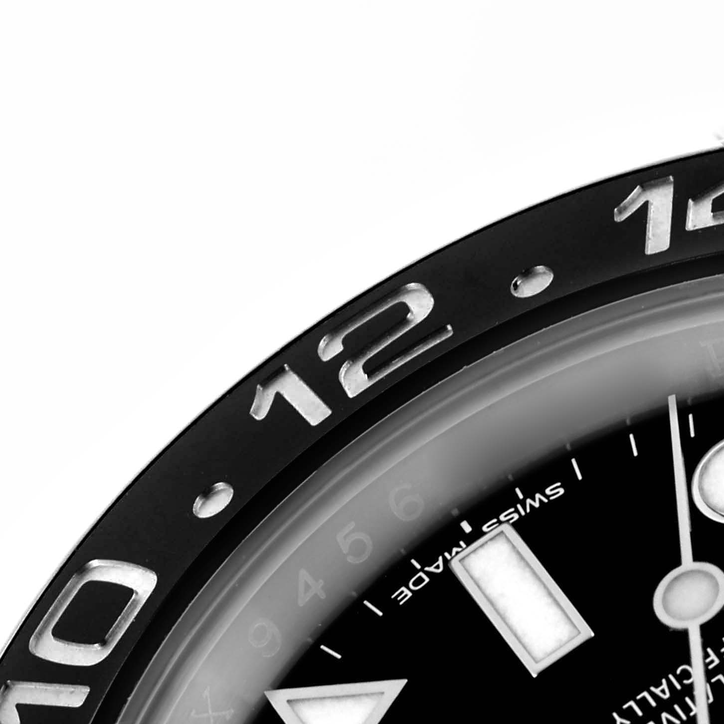 The image shows a close-up of the bezel and part of the dial on a Rolex GMT-Master 116710LN Men's Stainless Steel Black Dial 116710LN Men's Stainless Steel Black Dial watch, focusing on the 12 o'clock position.