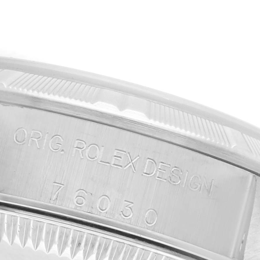 This image shows a close-up of the side of a Rolex Oyster Perpetual 76030 Women's Stainless Steel White Dial 76030 Women's Stainless Steel White Dial watch, featuring engraved text.