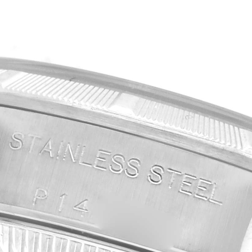 The image shows a close-up of the side of a Rolex Oyster Perpetual 76030 Women's Stainless Steel White Dial 76030 Women's Stainless Steel White Dial watch case, highlighting the "STAINLESS STEEL" engraving.