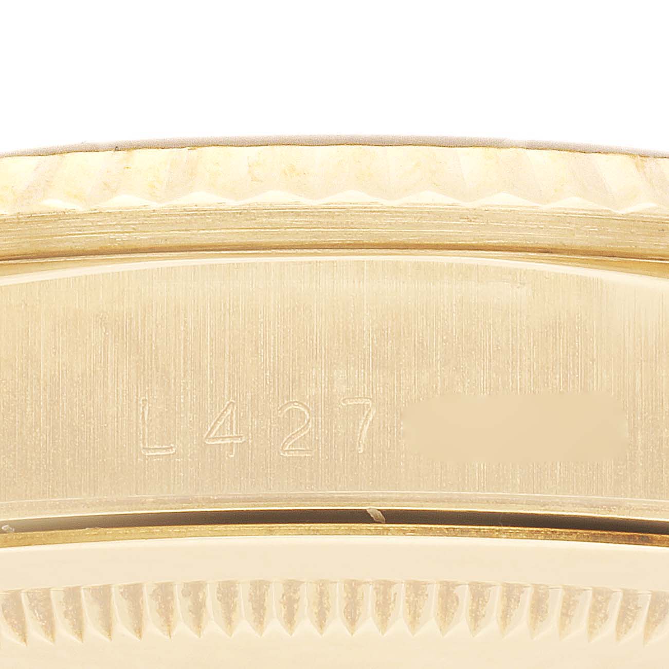 The image shows a close-up of the case back and part of the bezel of a Rolex President 18238 Men
s Yellow Gold Champagne Dial 18238 Men
s Yellow Gold Champagne Dial model watch, focusing on the serial number engraving.