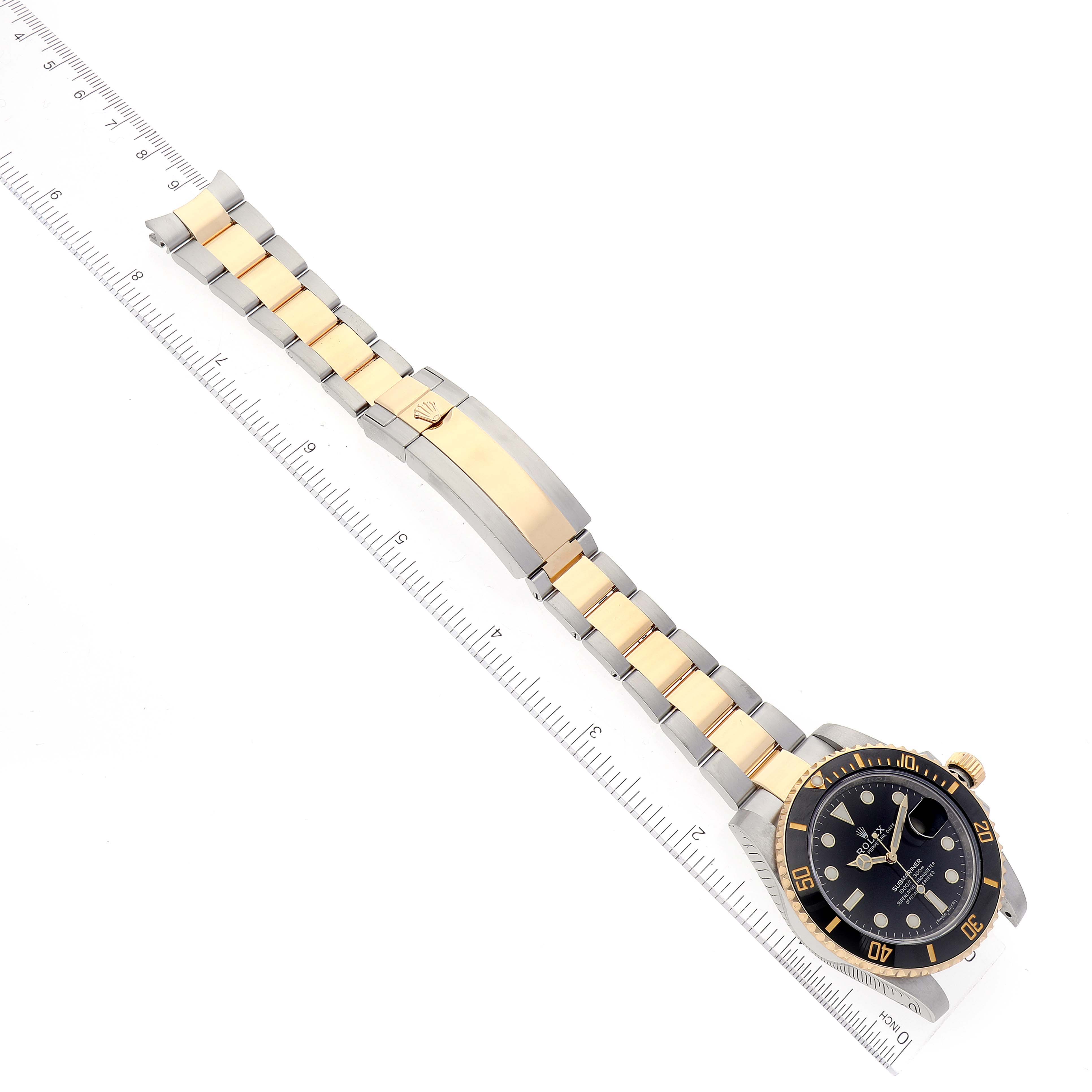 The image shows a top-down view of the Rolex Submariner 116613 Men's Steel and Gold (two tone) Black Dial 116613 Men's Steel and Gold (two tone) Black Dial watch, fully extended with its two-tone bracelet and a ruler alongside.