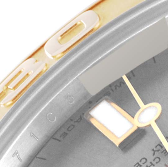 This close-up image of a Rolex Yacht-Master 168623 Men's Steel and Gold (two tone) Grey Dial 168623 Men's Steel and Gold (two tone) Grey Dial watch shows the bezel with a portion of the dial and a hand.