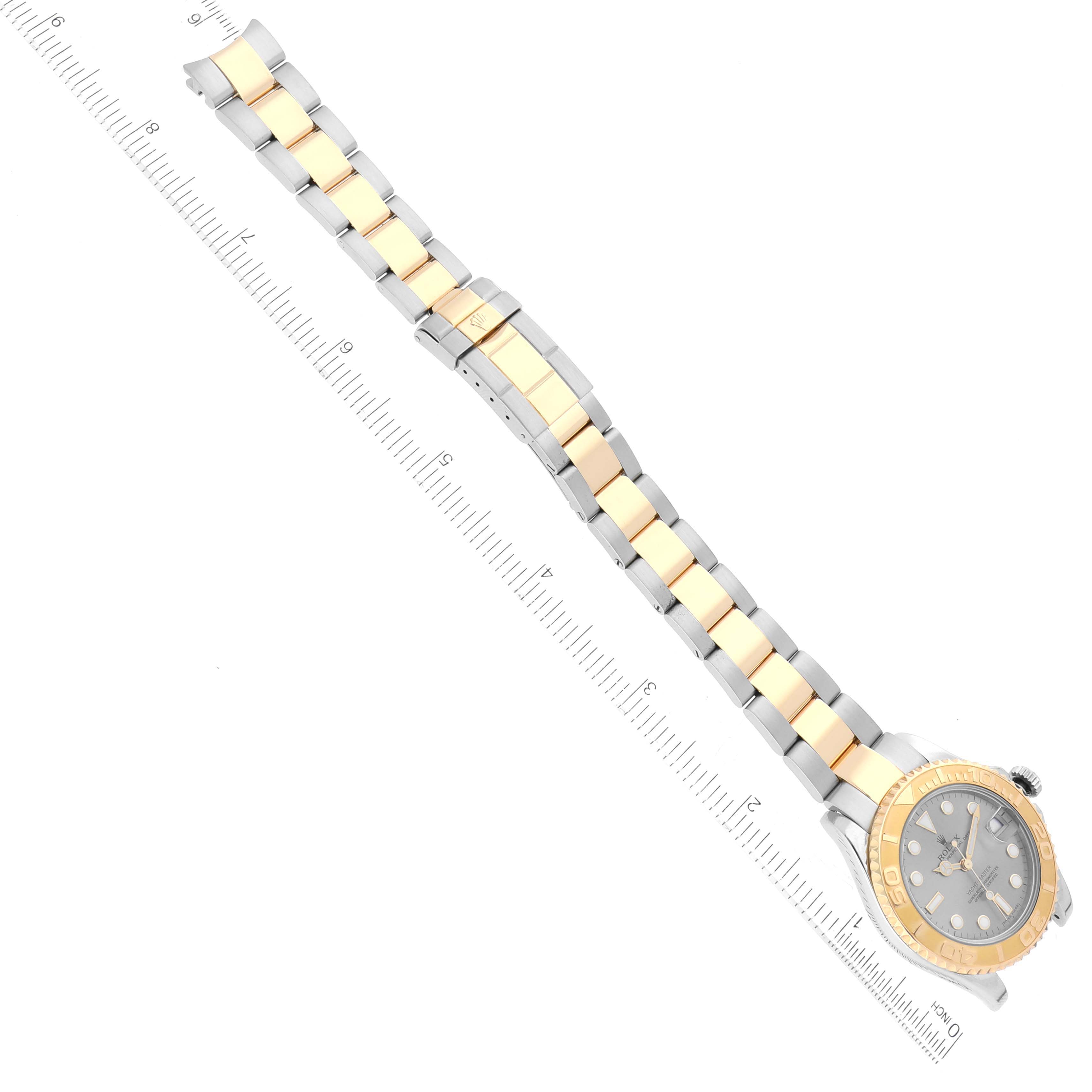 The image shows a top view of a Rolex Yacht-Master 168623 Men's Steel and Gold (two tone) Grey Dial 168623 Men's Steel and Gold (two tone) Grey Dial watch, displaying its dial, bezel, and metal bracelet with a ruler for measurement.