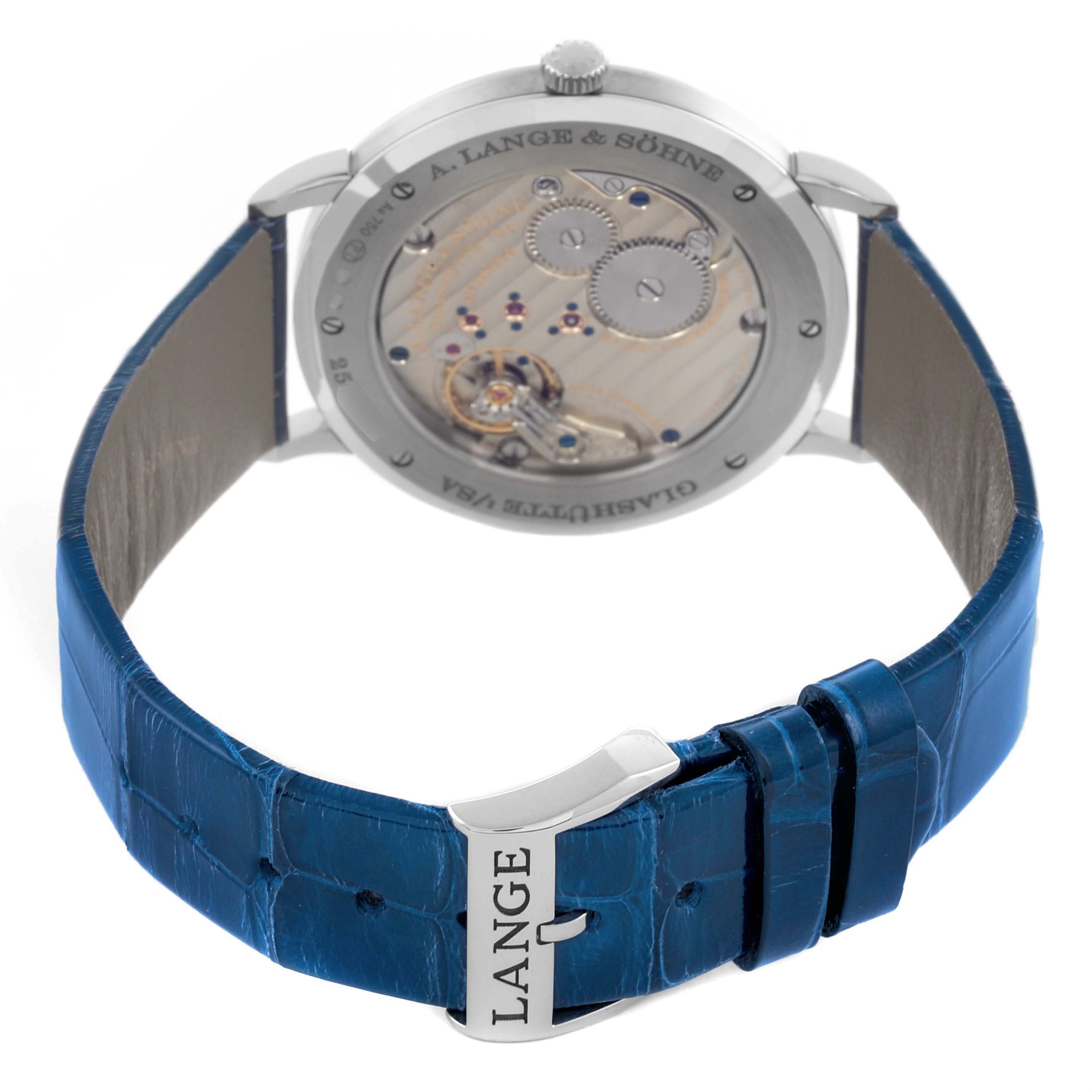 The A. Lange & Sohne Saxonia 205.086 Men's White Gold Blue Dial watch is shown from a rear angle, highlighting its movement and blue leather strap with clasp.