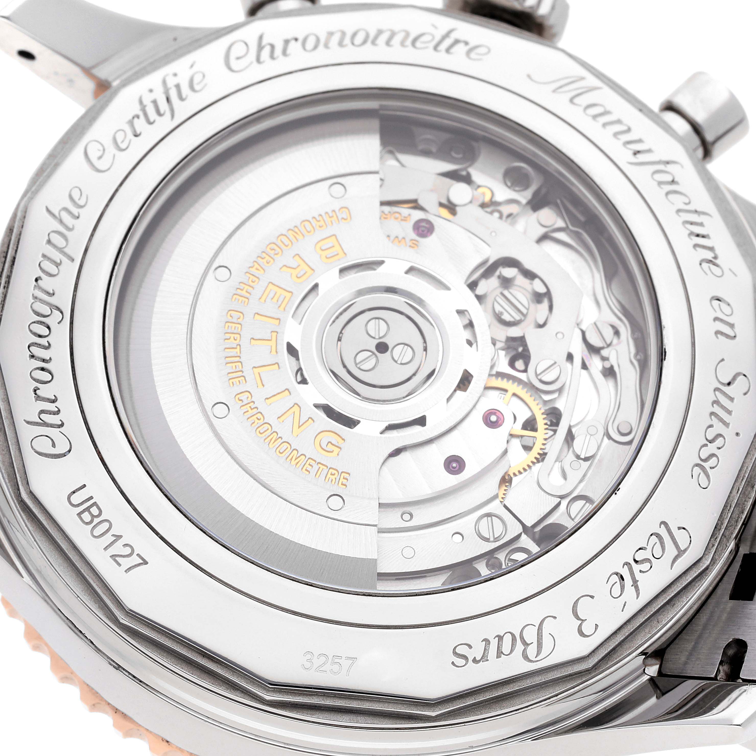 The image shows the back of a Breitling Navitimer UB0127 Men's Steel and Gold (two tone) Black Dial UB0127 Men's Steel and Gold (two tone) Black Dial watch, revealing the intricate inner movements and engravings.