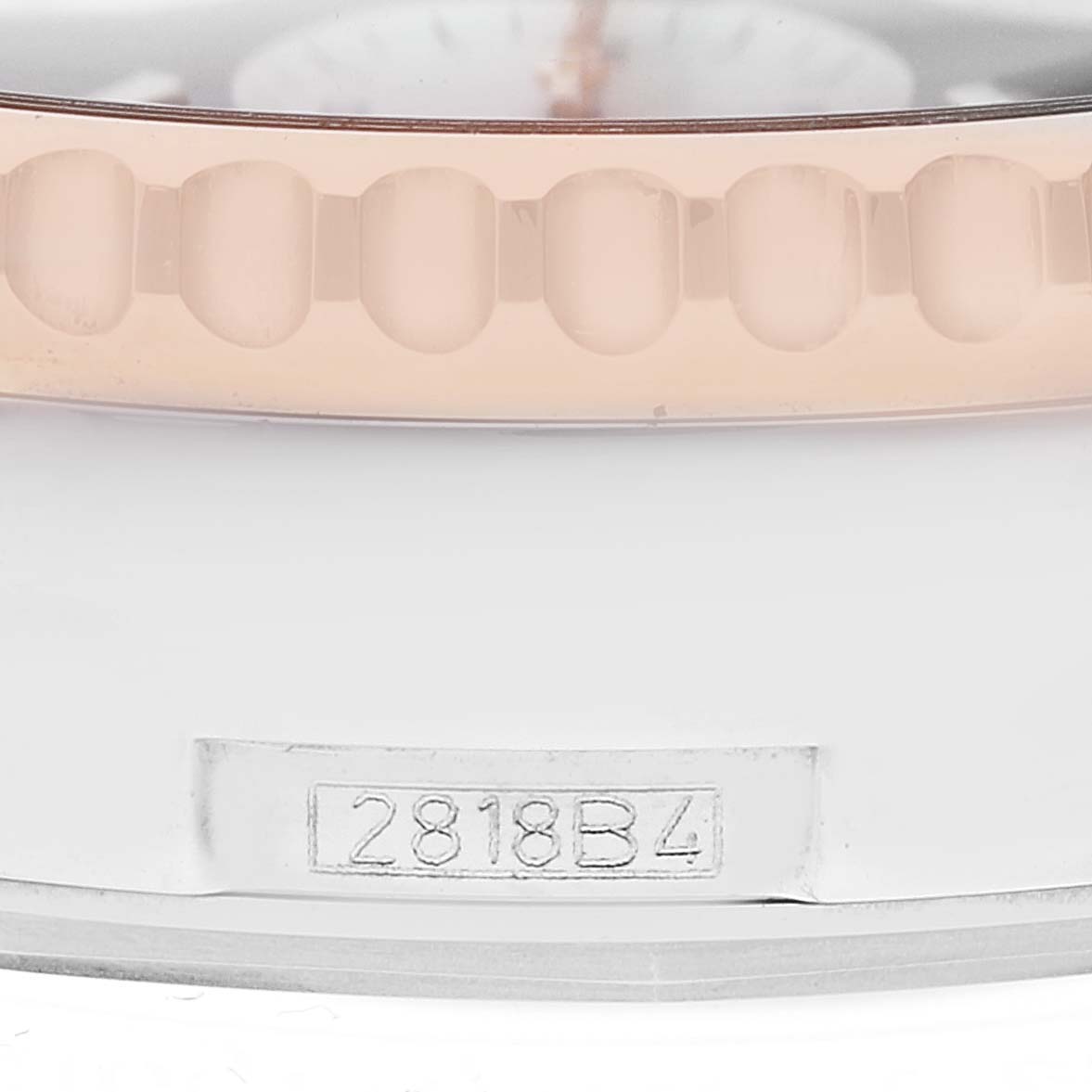 This close-up image of a Breitling Navitimer UB0127 Men's Steel and Gold (two tone) Black Dial UB0127 Men's Steel and Gold (two tone) Black Dial watch shows part of the bezel and a serial number engraving.