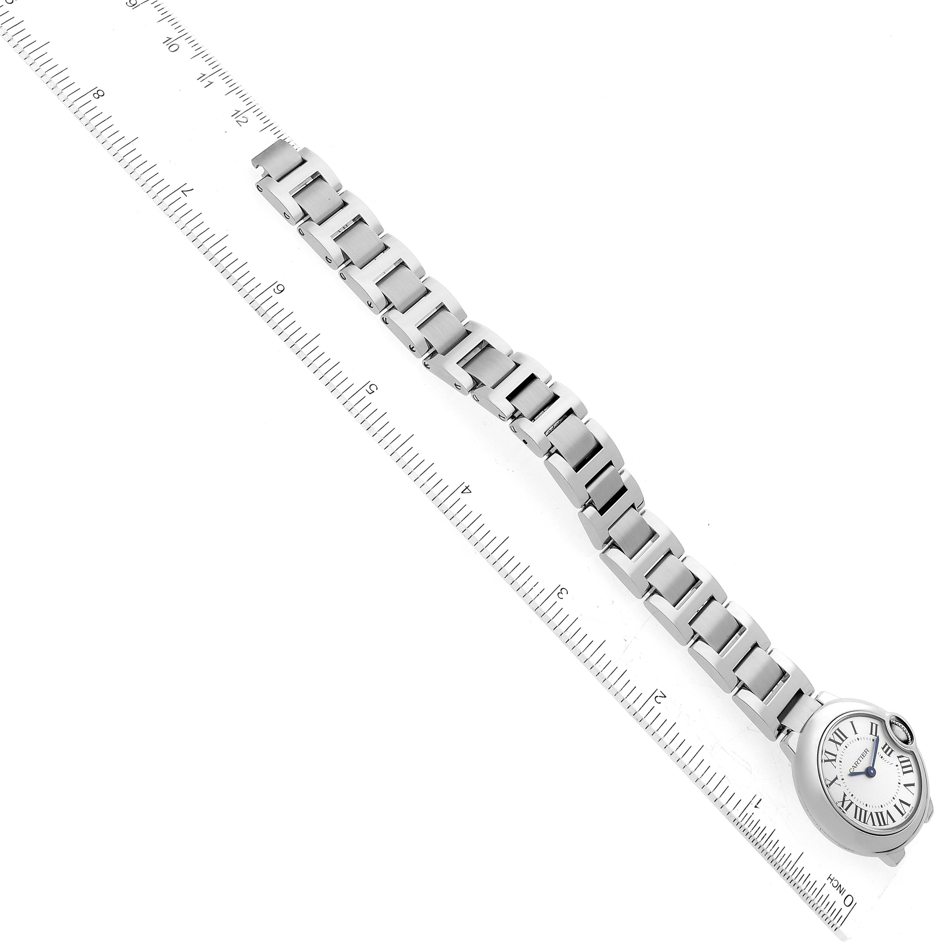 The image shows an overhead view of a Ballon Bleu de Cartier watch alongside a ruler to measure the metal bracelet length.