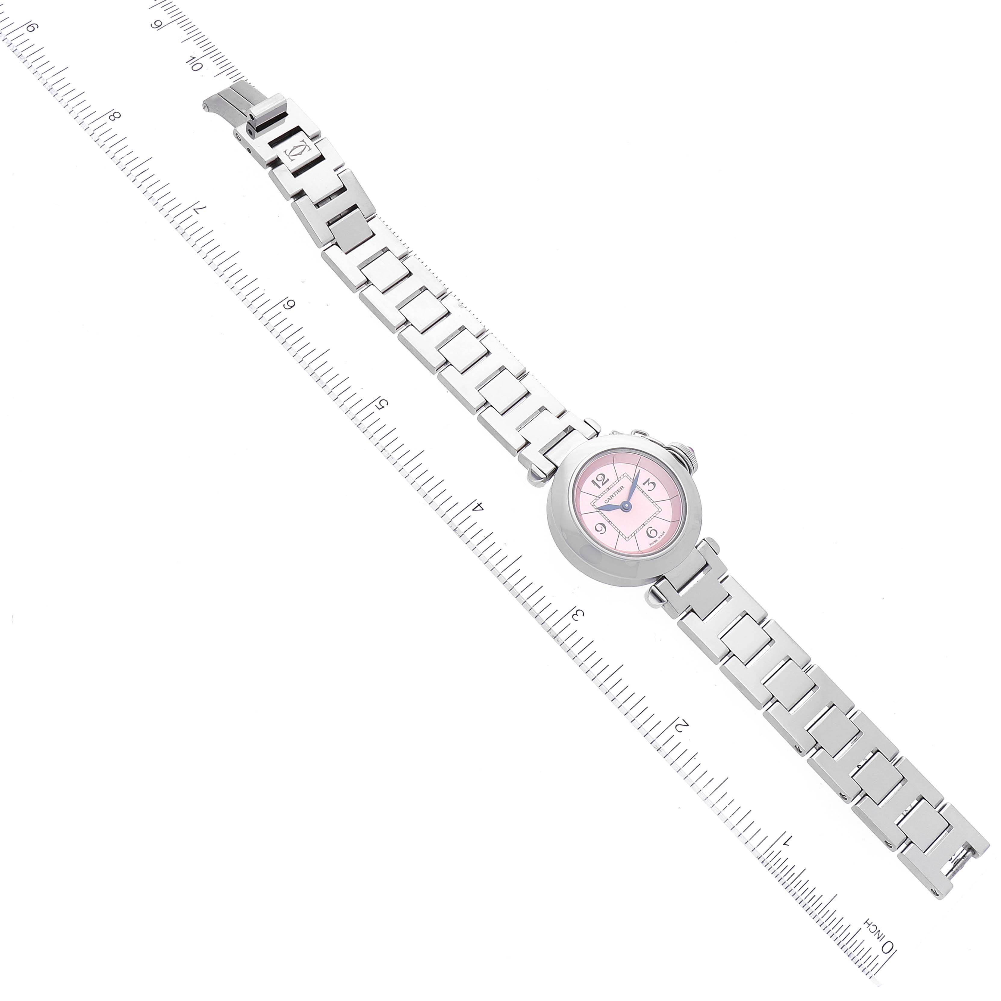 The image shows a top-down view of a Cartier Pasha W3140008 Women's Stainless Steel Pink Dial W3140008 Women's Stainless Steel Pink Dial model watch with a metal bracelet and a pink dial, placed next to a ruler.