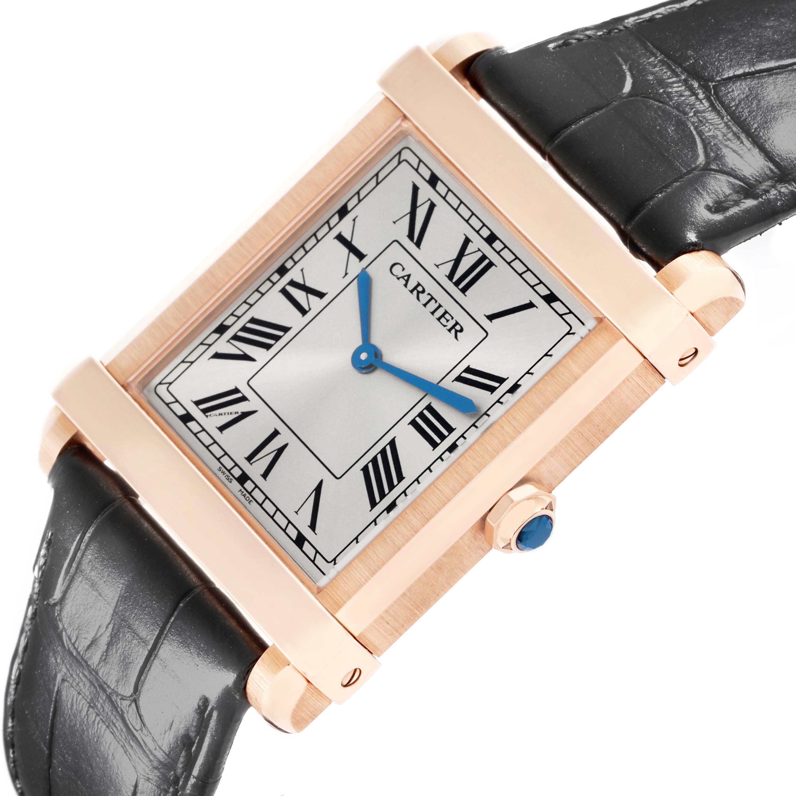 The Cartier Tank Louis WGTA0075 Men's Rose Gold Silver Dial watch is shown at a tilted angle, revealing the dial, blue hands, and crown with a blue gem, along with a leather strap.