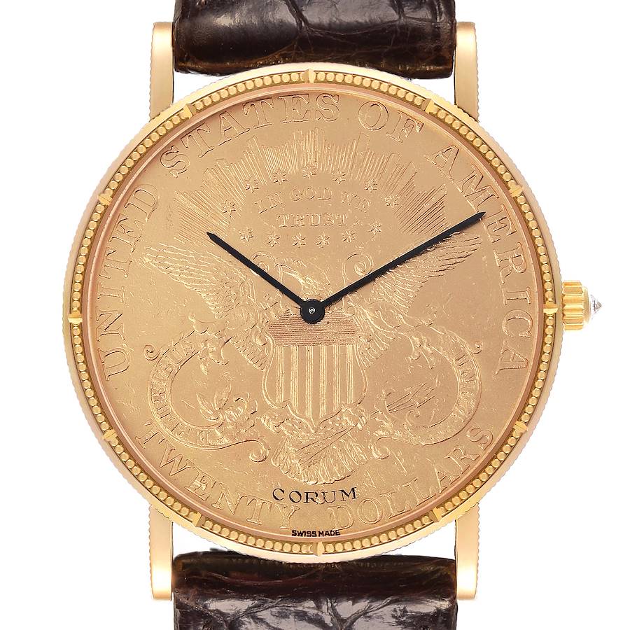 The Corum Coin Watch is shown from the front, displaying its gold coin face with a leather strap and a side crown.