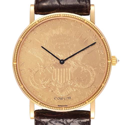 The Corum Coin Watch is shown from the front, displaying the detailed coin dial, crown, and part of the leather strap.