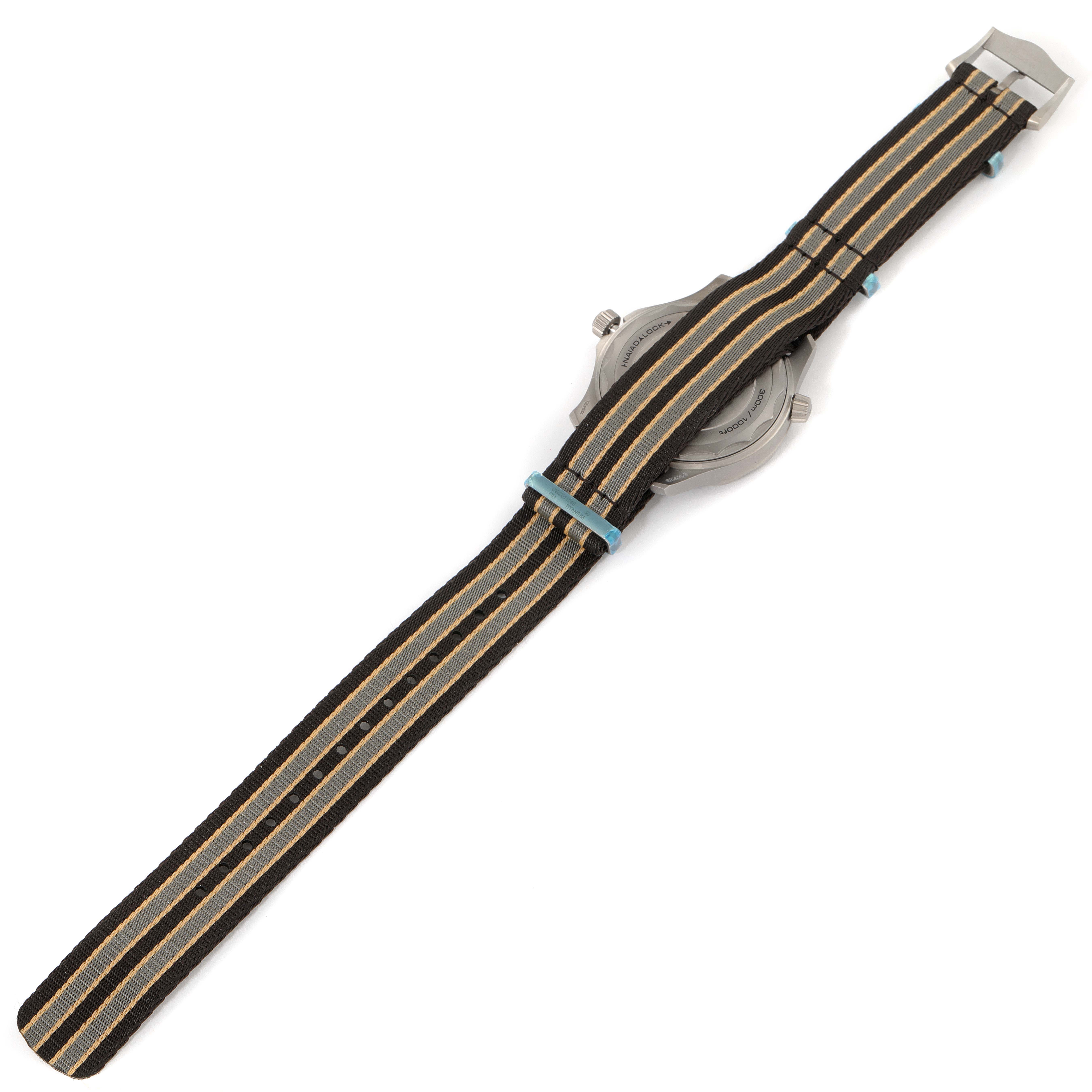 The image shows the back of an Omega Seamaster 210.92.42.20.01.001 Men's Titanium Brown Dial 210.92.42.20.01.001 Men's Titanium Brown Dial watch with a striped NATO strap.