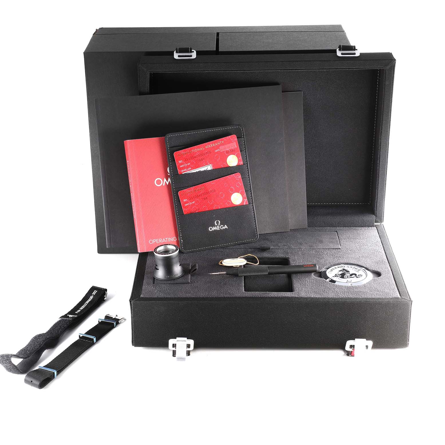 The image shows a complete boxed set of accessories for the Omega Speedmaster 311.30.42.30.01.005 Men
s Stainless Steel Black Dial 311.30.42.30.01.005 Men
s Stainless Steel Black Dial, including documents, straps, a loupe, and a medallion.