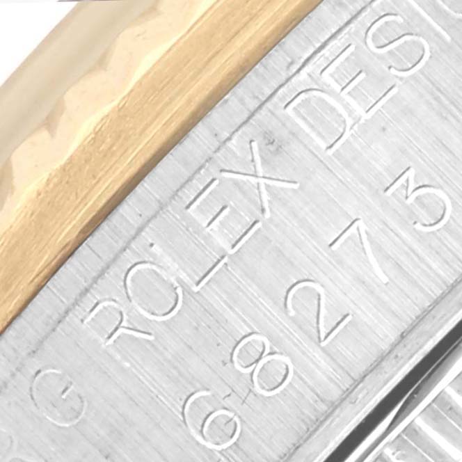 The image shows a close-up angle of a Rolex Mid-Size 68273 Women's Steel and Gold (two tone) White Dial 68273 Women's Steel and Gold (two tone) White Dial model's engraved bezel and case edge.