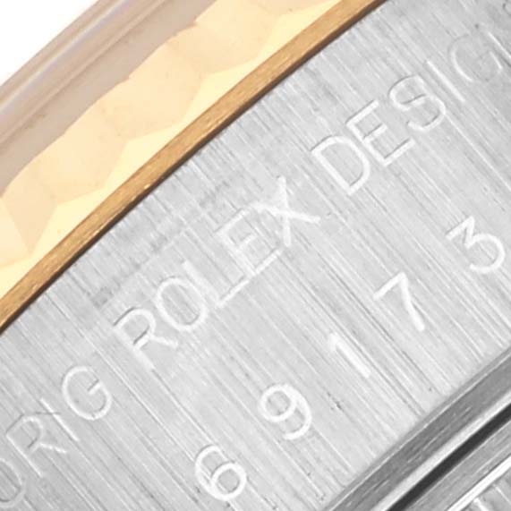 This image shows a close-up of the watch casing of a Rolex Datejust 69173 Women's Steel and Gold (two tone) Red Dial 69173 Women's Steel and Gold (two tone) Red Dial, highlighting the brushed metal texture and engraved text.