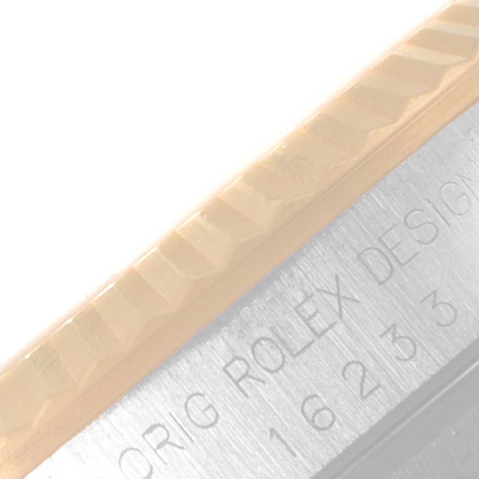 The image shows a close-up angle of the bezel and case side of a Rolex Datejust 16233 Men's Steel and Gold (two tone) Champagne Dial 16233 Men's Steel and Gold (two tone) Champagne Dial model, highlighting the fluted design and engraved text.