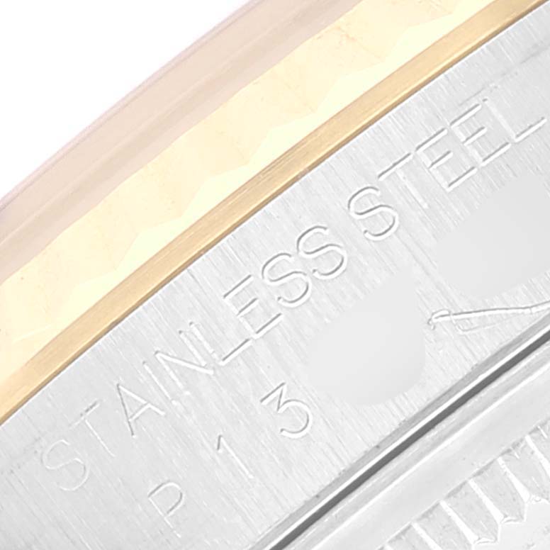 This image shows a close-up of a Rolex Datejust 16233 Men's Steel and Gold (two tone) Black Dial 16233 Men's Steel and Gold (two tone) Black Dial's stainless steel and gold bezel with engraved text.