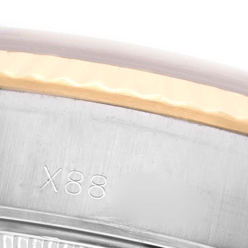 The image shows a close-up of the Rolex Datejust 69173 Women's Steel and Gold (two tone) Champagne Dial 69173 Women's Steel and Gold (two tone) Champagne Dial's bezel and case edge with partial engravings.
