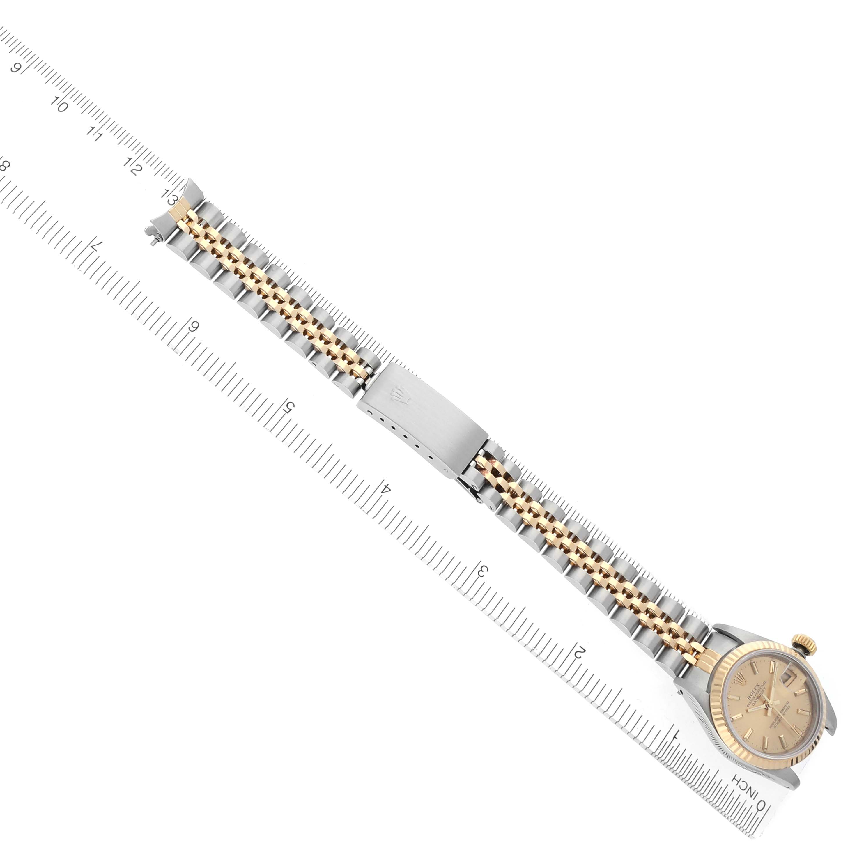 The Rolex Datejust 69173 Women's Steel and Gold (two tone) Champagne Dial 69173 Women's Steel and Gold (two tone) Champagne Dial watch is displayed at an angled view showing the full bracelet and dial alongside a ruler for scale.