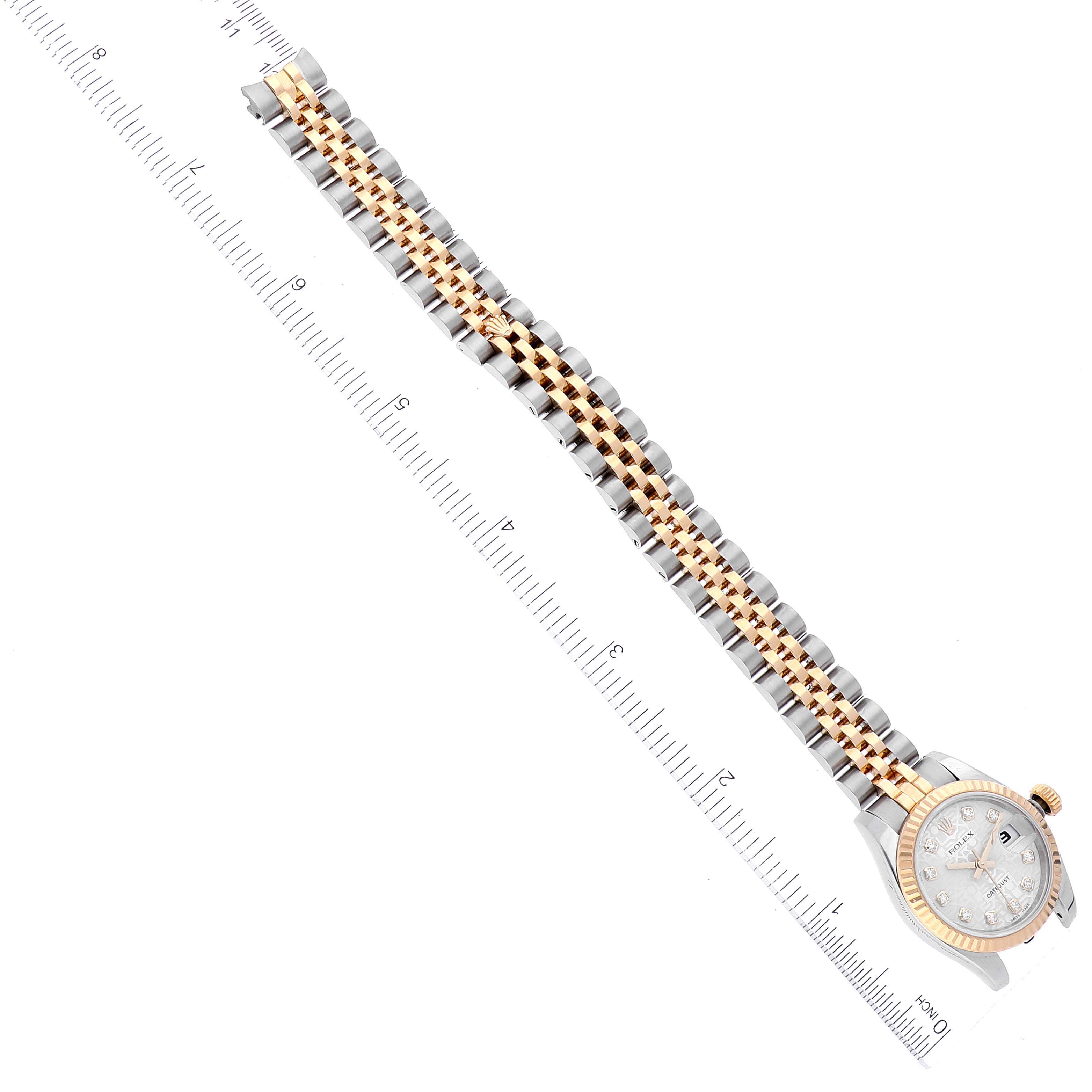 The image shows a top-down view of a Rolex Datejust 179173 Women's Steel and Gold (two tone) Silver Dial 179173 Women's Steel and Gold (two tone) Silver Dial watch, highlighting its case and two-tone metal bracelet against a ruler.