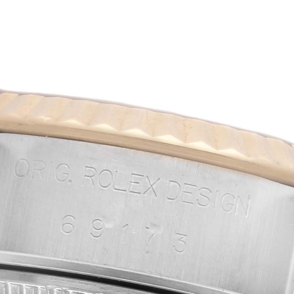 The image shows a close-up of the edge of a Rolex Datejust 69173 Women's Steel and Gold (two tone) Champagne Dial 69173 Women's Steel and Gold (two tone) Champagne Dial watch, highlighting the fluted bezel and model engraving.