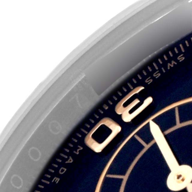 The image shows a close-up of the bezel and part of the dial from a Rolex Daytona 116523 Men
s Steel and Gold (two tone) Black Dial 116523 Men
s Steel and Gold (two tone) Black Dial watch.