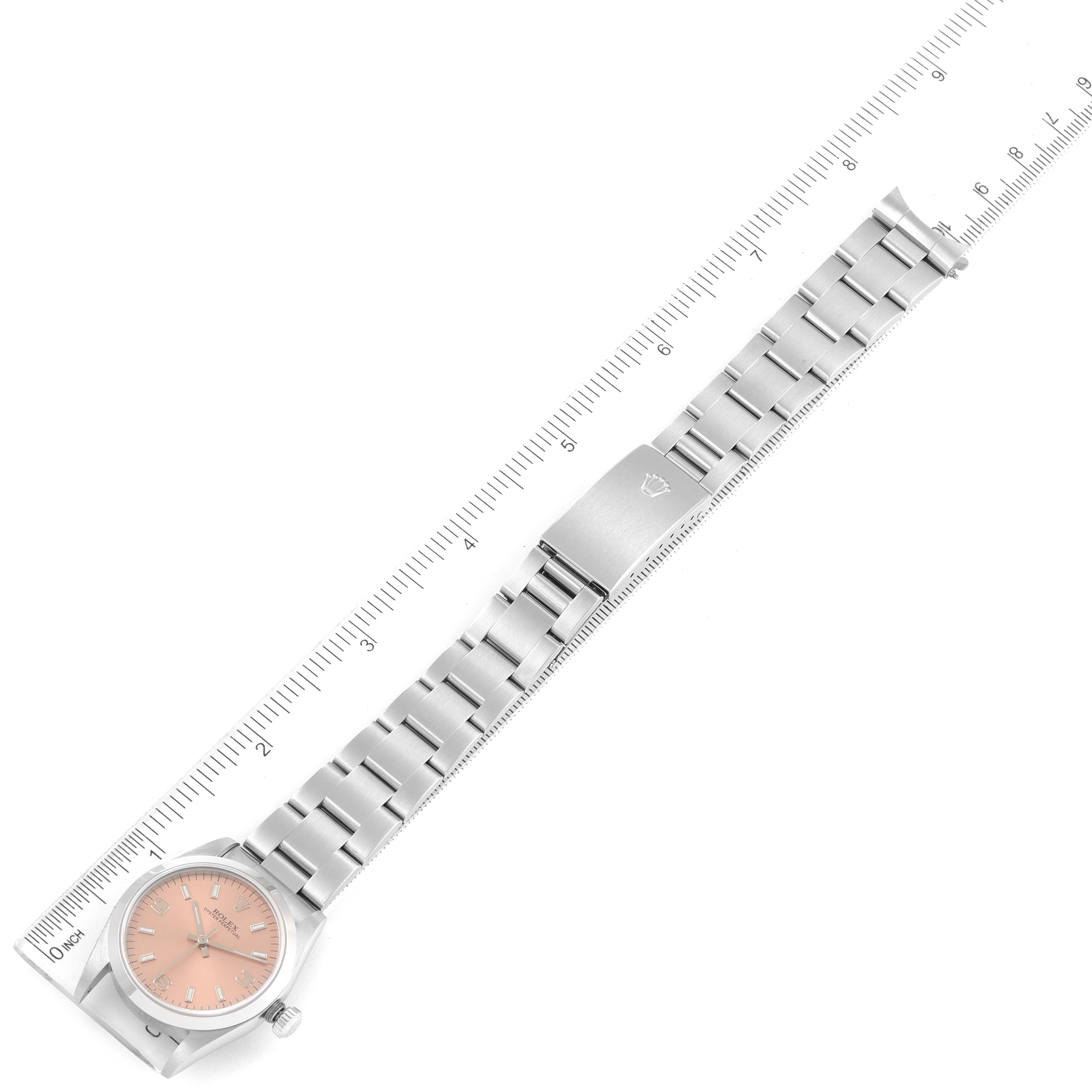 The image shows a top-down view of a Mid-Size Rolex watch, including the face, strap, and clasp against a ruler for size reference.