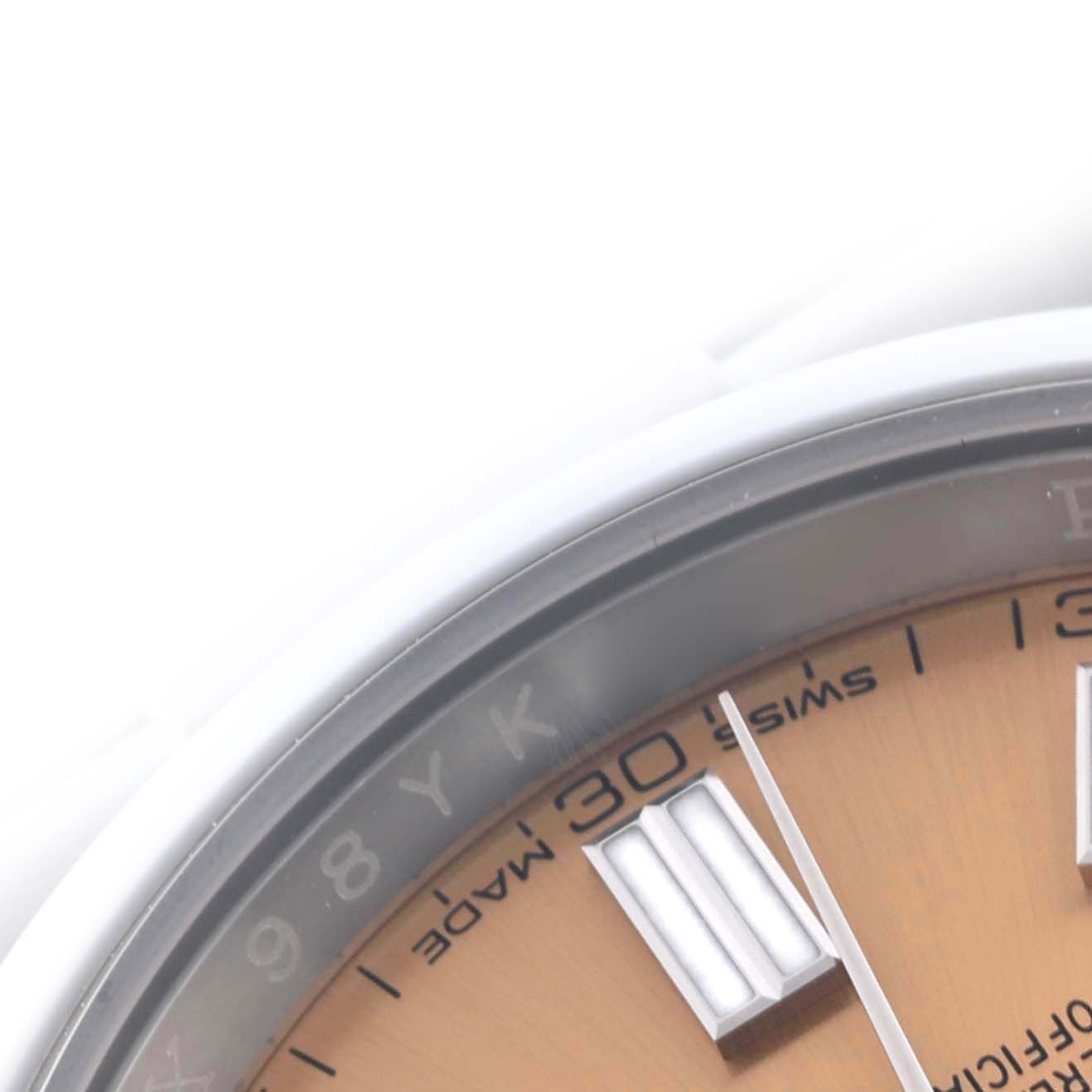 The image shows a close-up of the dial and bezel of a Rolex Oyster Perpetual 116000 Men's Stainless Steel Champagne Dial 116000 Men's Stainless Steel Champagne Dial watch, focusing on the hour markers and minute track.