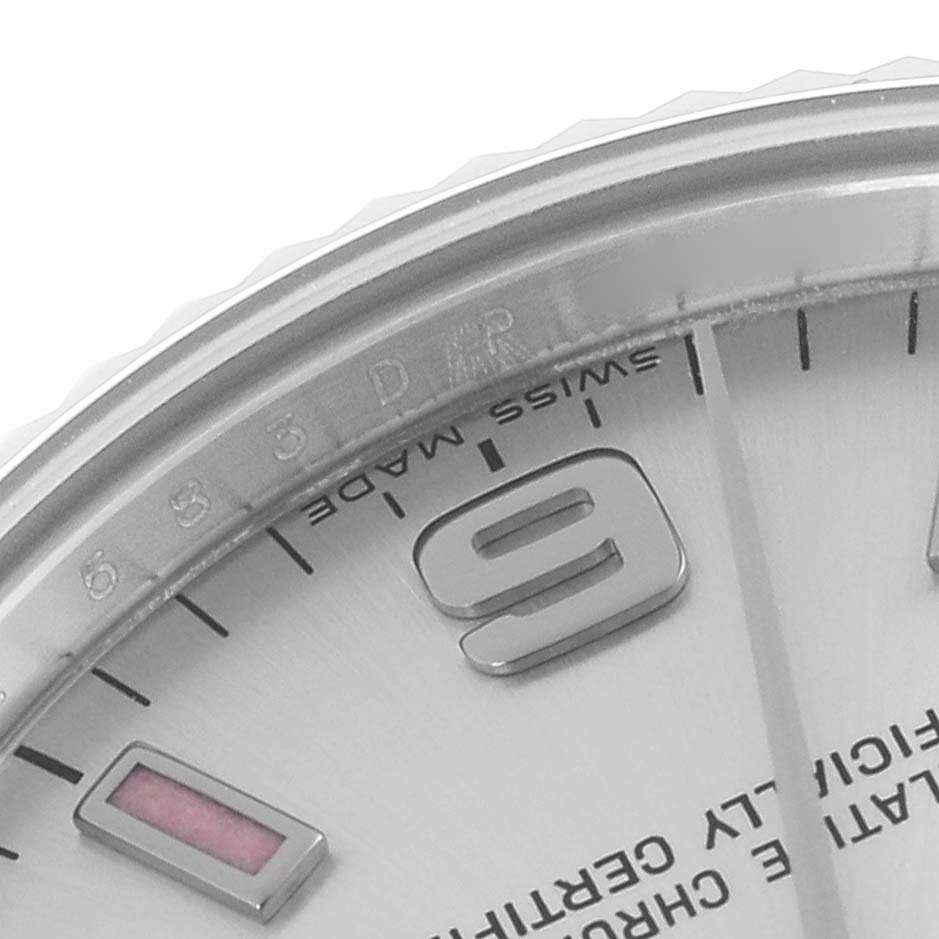 The image shows a close-up angle of the dial and bezel of a mid-size Rolex watch, highlighting numerals and indices.