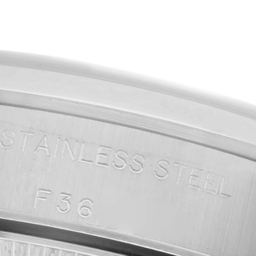 This image shows the side of the Rolex Oyster Perpetual 76080 Women's Stainless Steel Pink Dial 76080 Women's Stainless Steel Pink Dial watch, highlighting the engraved text on the stainless steel casing.