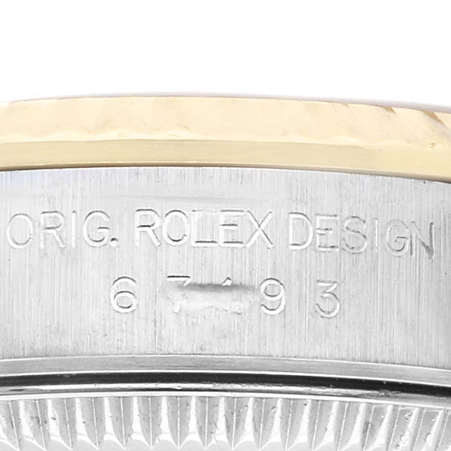 This image shows a close-up of the side of a Rolex Oyster Perpetual 67193 Women's Steel and Gold (two tone) Champagne Dial 67193 Women's Steel and Gold (two tone) Champagne Dial watch, highlighting the "ORIG. ROLEX DESIGN" engraving and partial serial number.