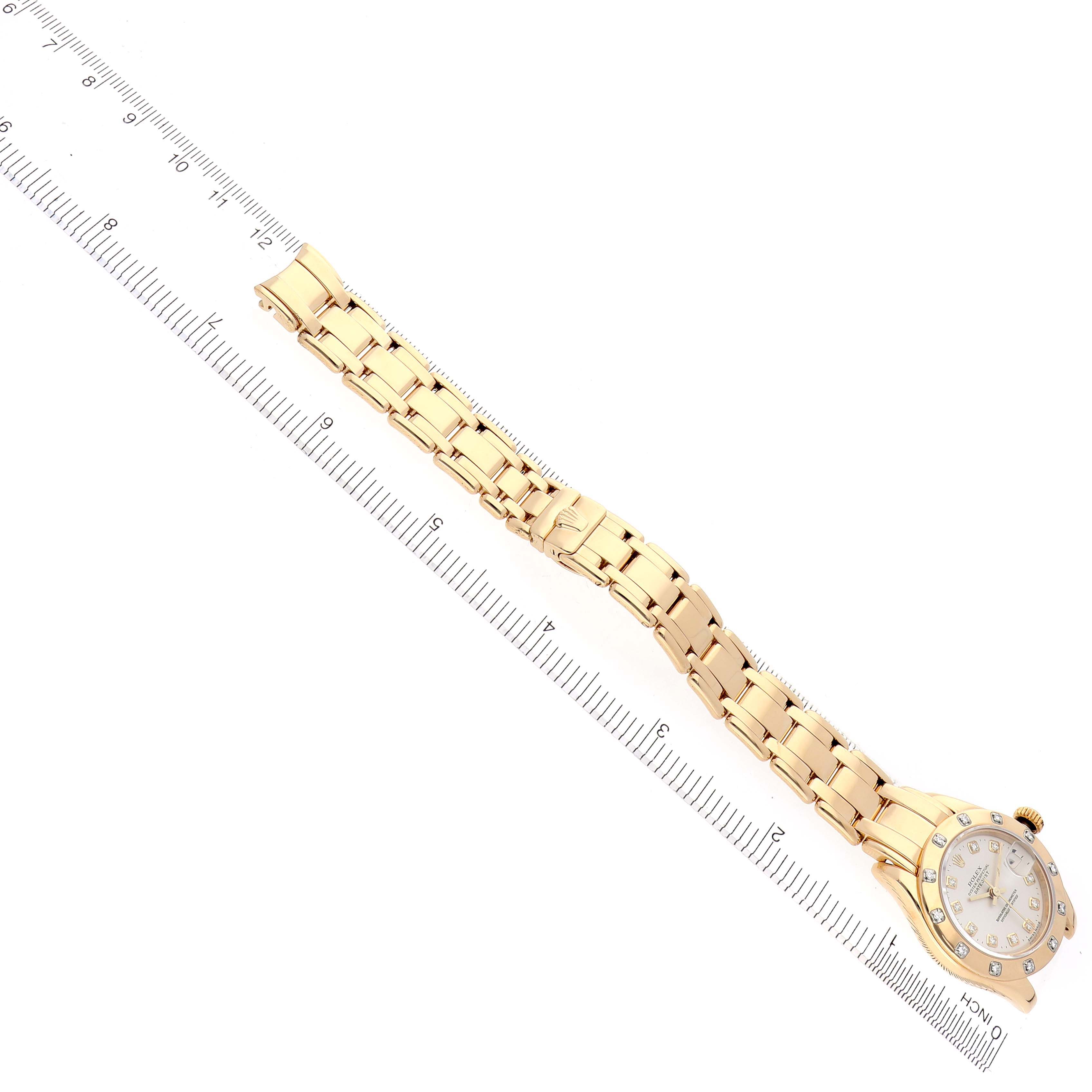 The Rolex Pearlmaster 69318 Women's Yellow Gold Silver Dial 69318 Women's Yellow Gold Silver Dial watch is shown at an oblique angle, displaying the full bracelet and part of the watch face alongside a ruler.