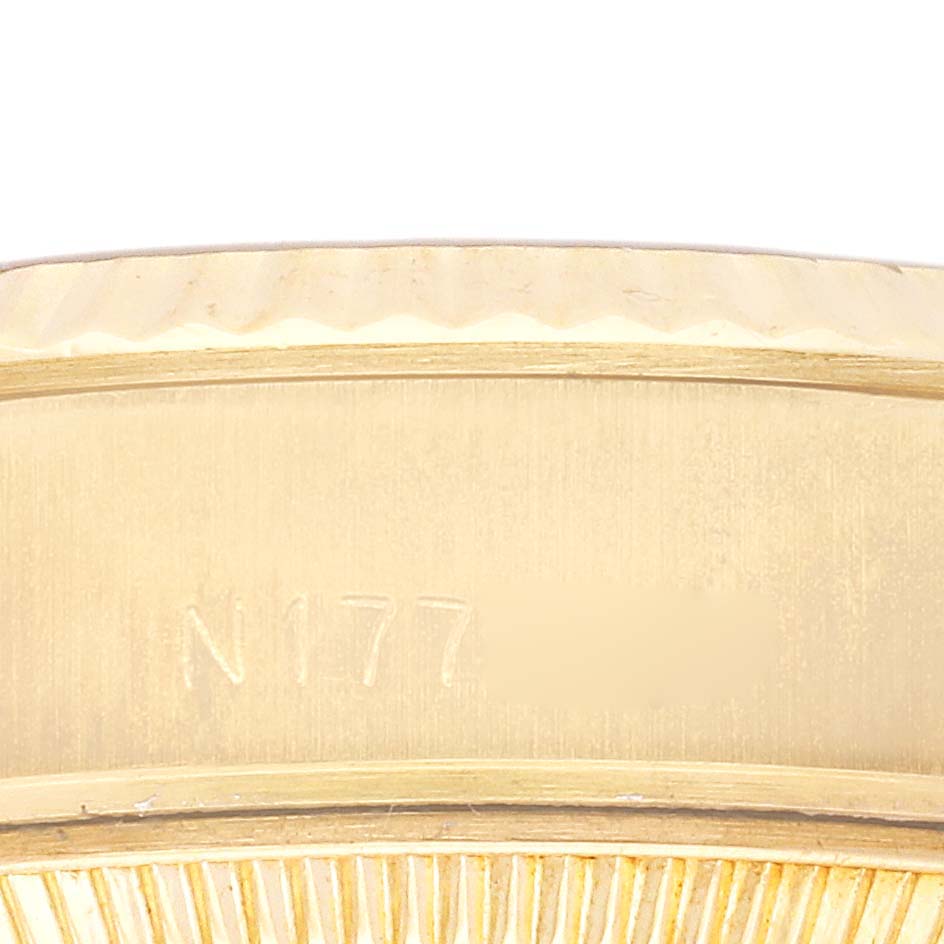 The image shows a close-up of the side of a Rolex President 69178 Women's Yellow Gold Champagne Dial 69178 Women's Yellow Gold Champagne Dial watch, focusing on the engraved serial number area.