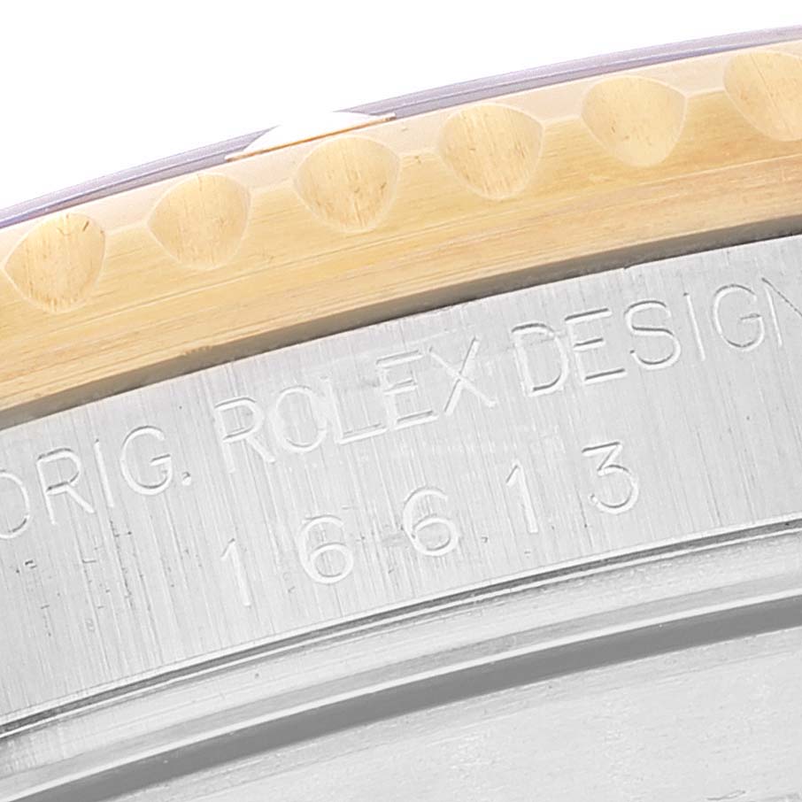 The image shows a close-up of the outer edge and bezel of a Rolex Submariner 16613 Men's Steel and Gold (two tone) Blue Dial 16613 Men's Steel and Gold (two tone) Blue Dial model with the model number 16613 engraved.