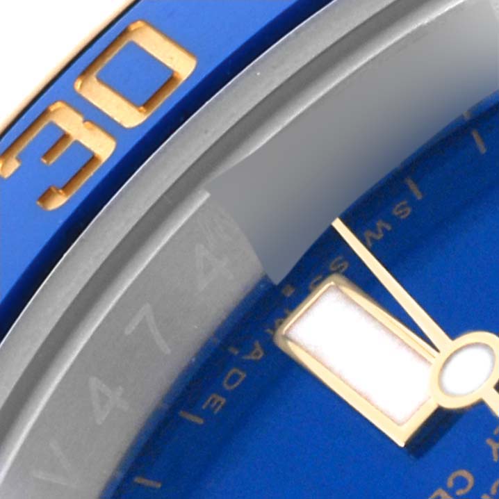 The image shows a close-up of the bezel and dial of the Rolex Submariner 116613LB Men's Steel and Gold (two tone) Blue Dial 116613LB Men's Steel and Gold (two tone) Blue Dial, highlighting the 30-minute mark and part of a blue dial.